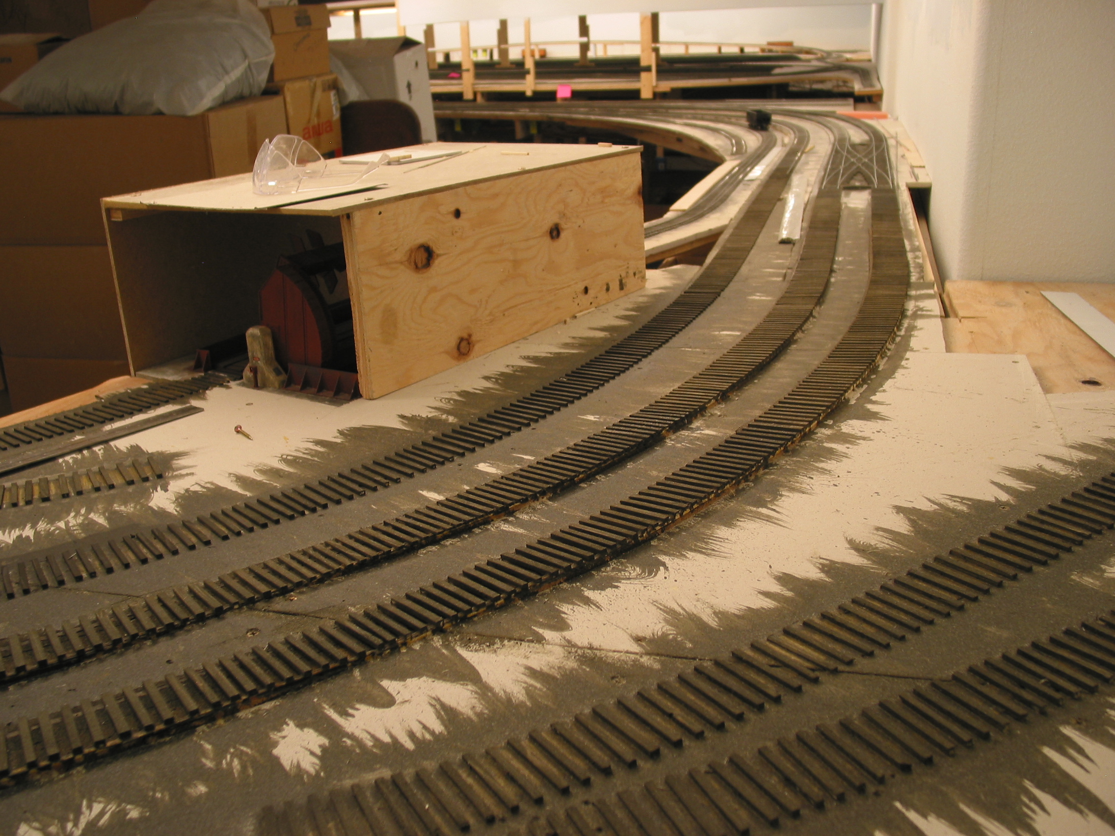  The ties are in place into Glen Forge. The Bayfield double-crossover can be seen in the distance&nbsp; looking down the mains. A plywood cocoon encases the rotary to protect from damage during this phase of construction. 