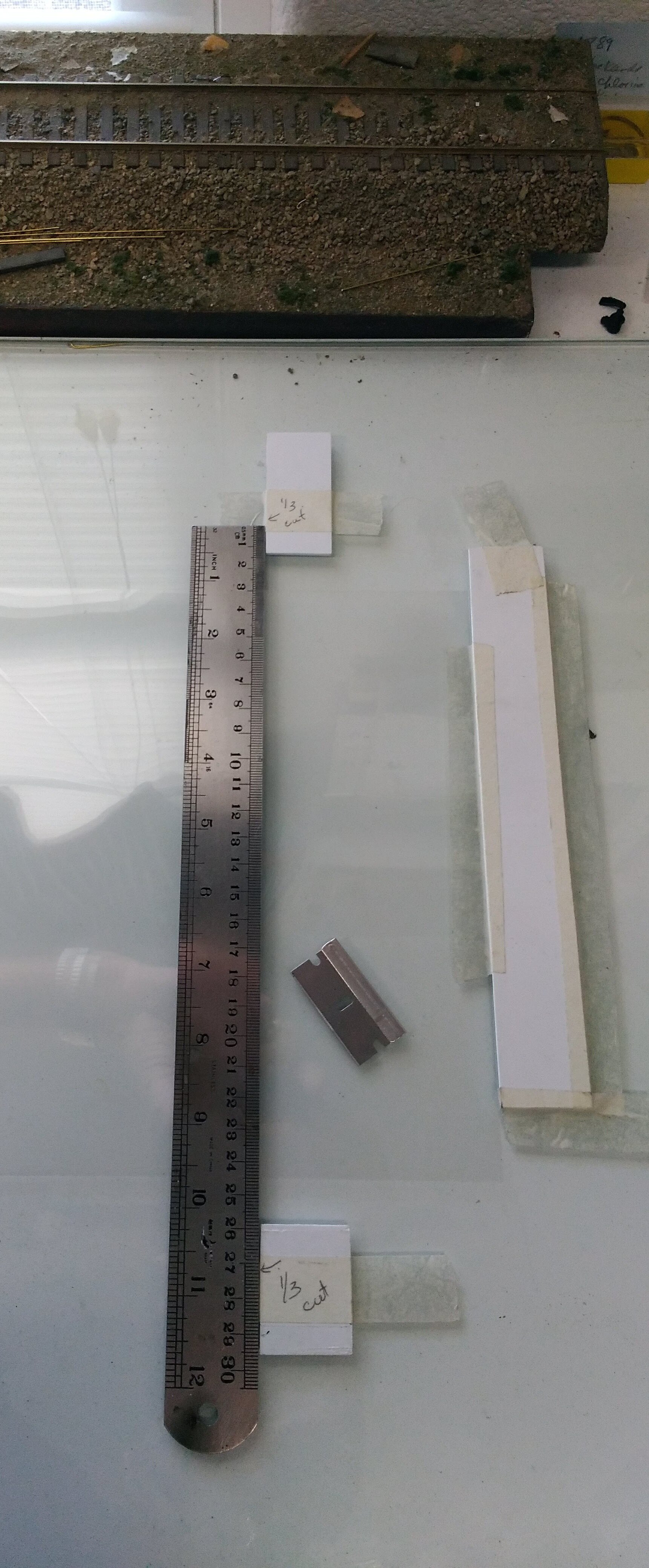  I taped some styrene guide stops to my glass-topped work bench after figuring out how to get the most number of pouch squares out of a 8.5x11” sheet of transparency film. While the width is the same as the car card, the height is more than the visib