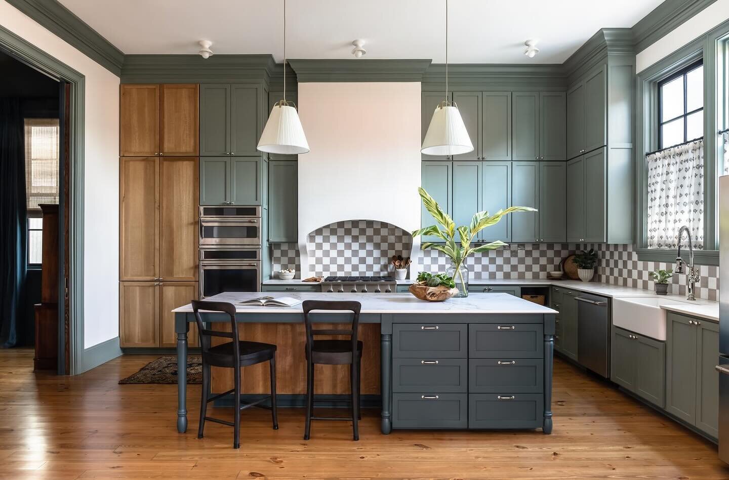 We opted for a casual yet luxurious eat-in kitchen at St Thomas Street. A checkered tile backsplash adds whimsy under a custom designed hood vent. White oak panels on the island and hidden pantry cupboard modernize the look while serving a practical 