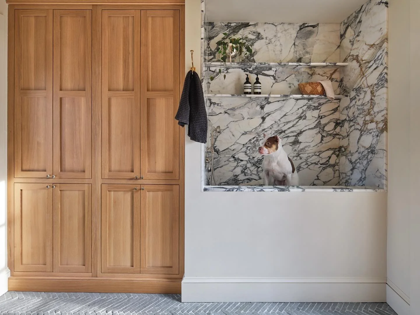 Situated between the kitchen and the garage is a bright and hard working mudroom with a marbled dog wash (hi, Beans 🐶), floor to ceiling storage, and a herringbone limestone floor by @francois.and.co 

Design : @cattaneostudios 
Millwork : @village_