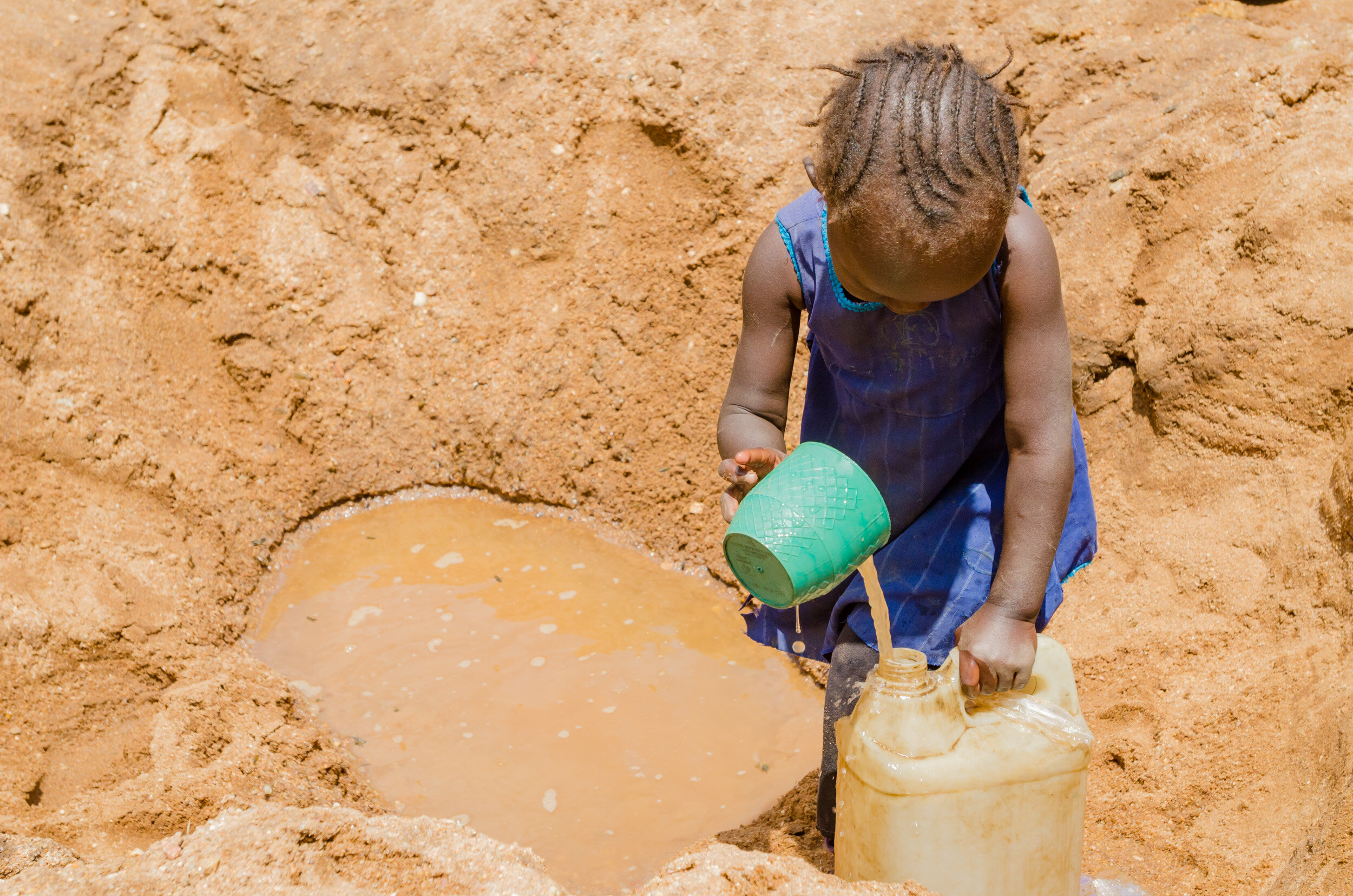 Pools of muddy water are dug and manually emptied into jugs that then have to be carried home. (Copy)