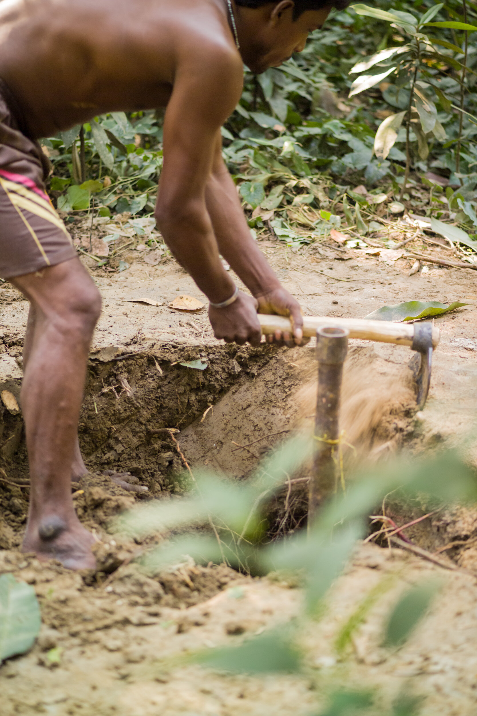 With the pump in place and only the pipe protruding from the ground, the rest of the well has to be dug out by hand.. (Copy)