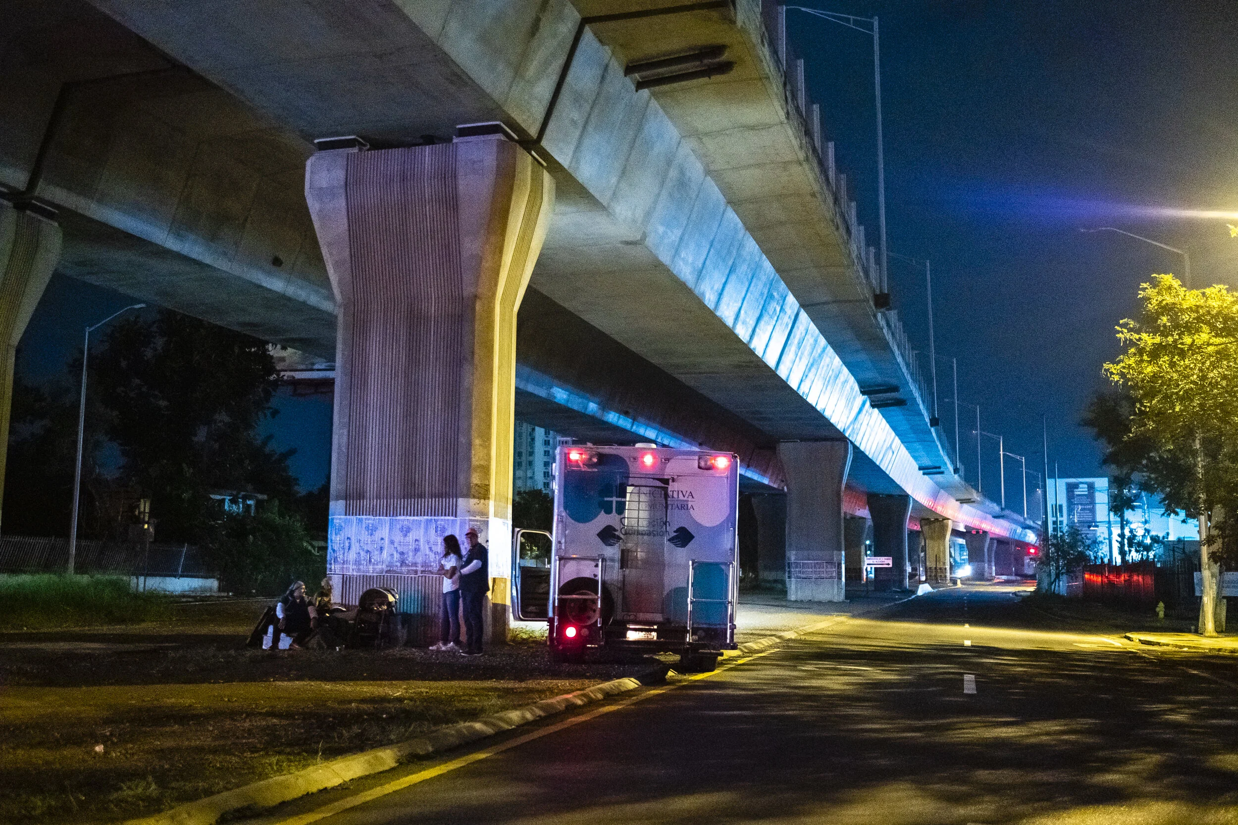  Operación Compasión’s volunteers visit an elderly homeless man under a highway bridge, offering comfort and a warm meal.  