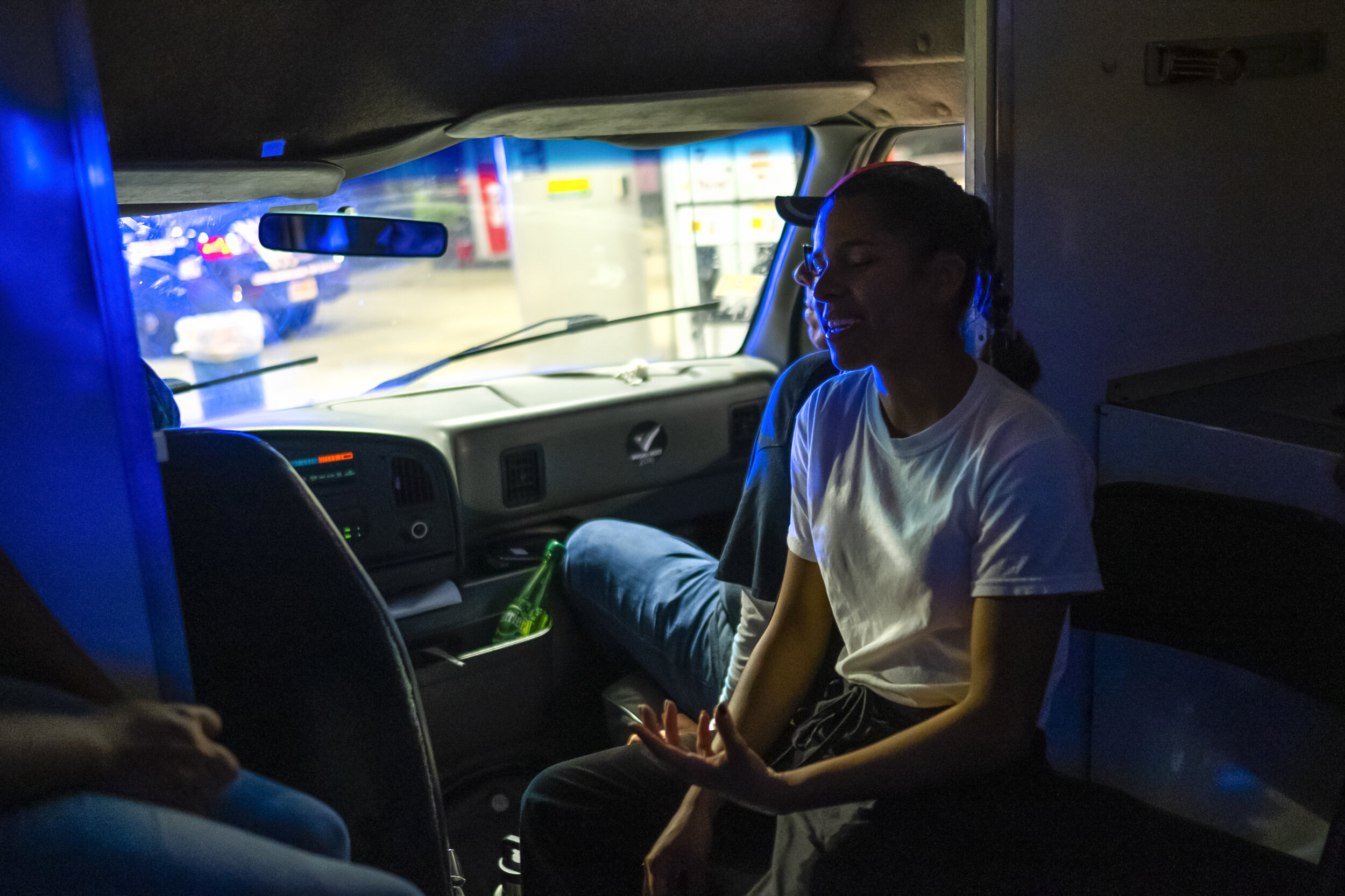  A young volunteer joyfully converses with her peers inside the van of Operación Compasión. 