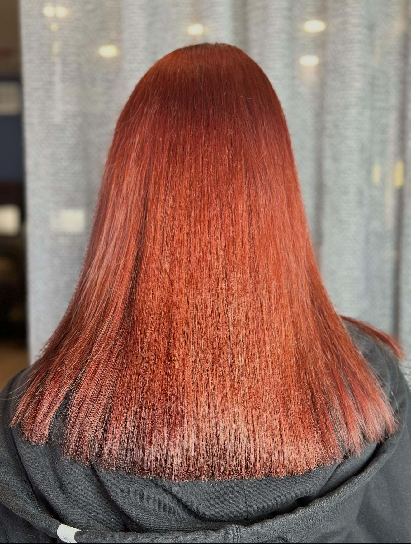 Vibrant all-over red hair color with sleek blunt cut in Clarendon Hills