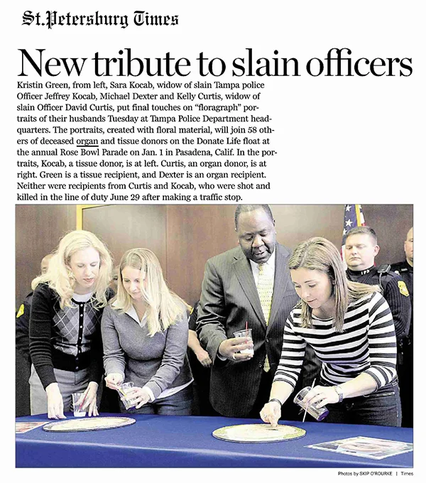 The widows of slain officers Jeffrey Kocab and David Curtis apply the finishing touches to their husbands' floraraph portraits at Tampa Police Department headquarters.