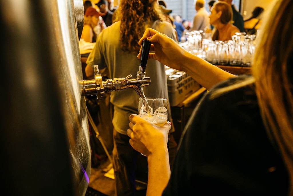A bartender pouring a beer off the tank