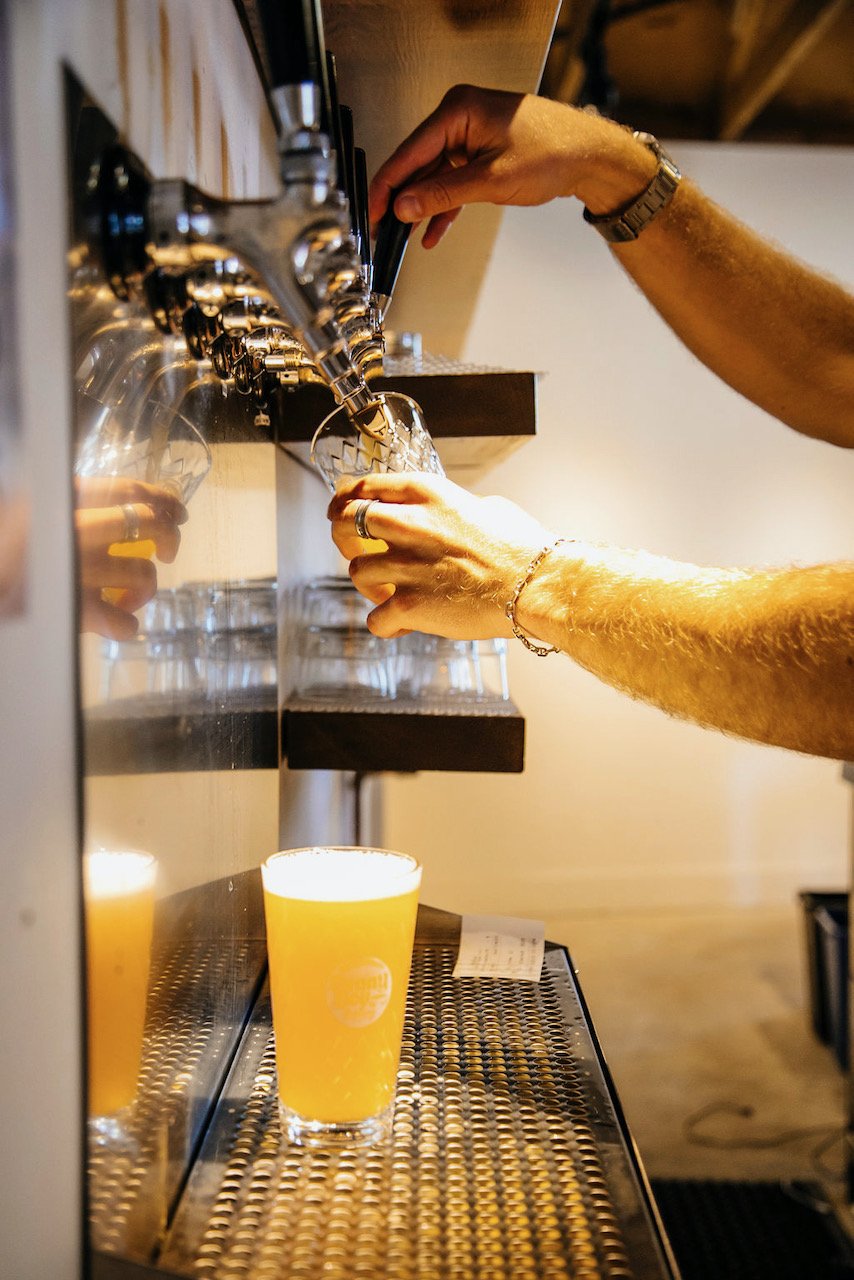 The bartender pouring a cider off the tap