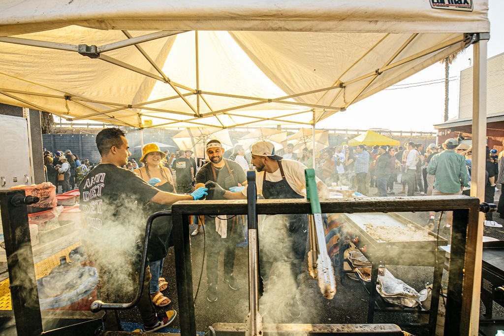 Chefs cooking food under a pop up tent