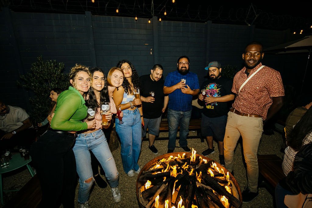 A group of people posing around the fire pit