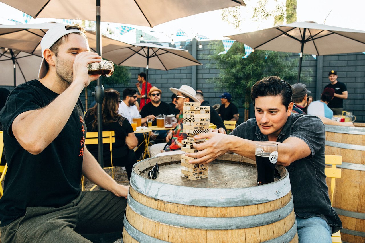 Two people playing jenga while drinking beer in the beer garden