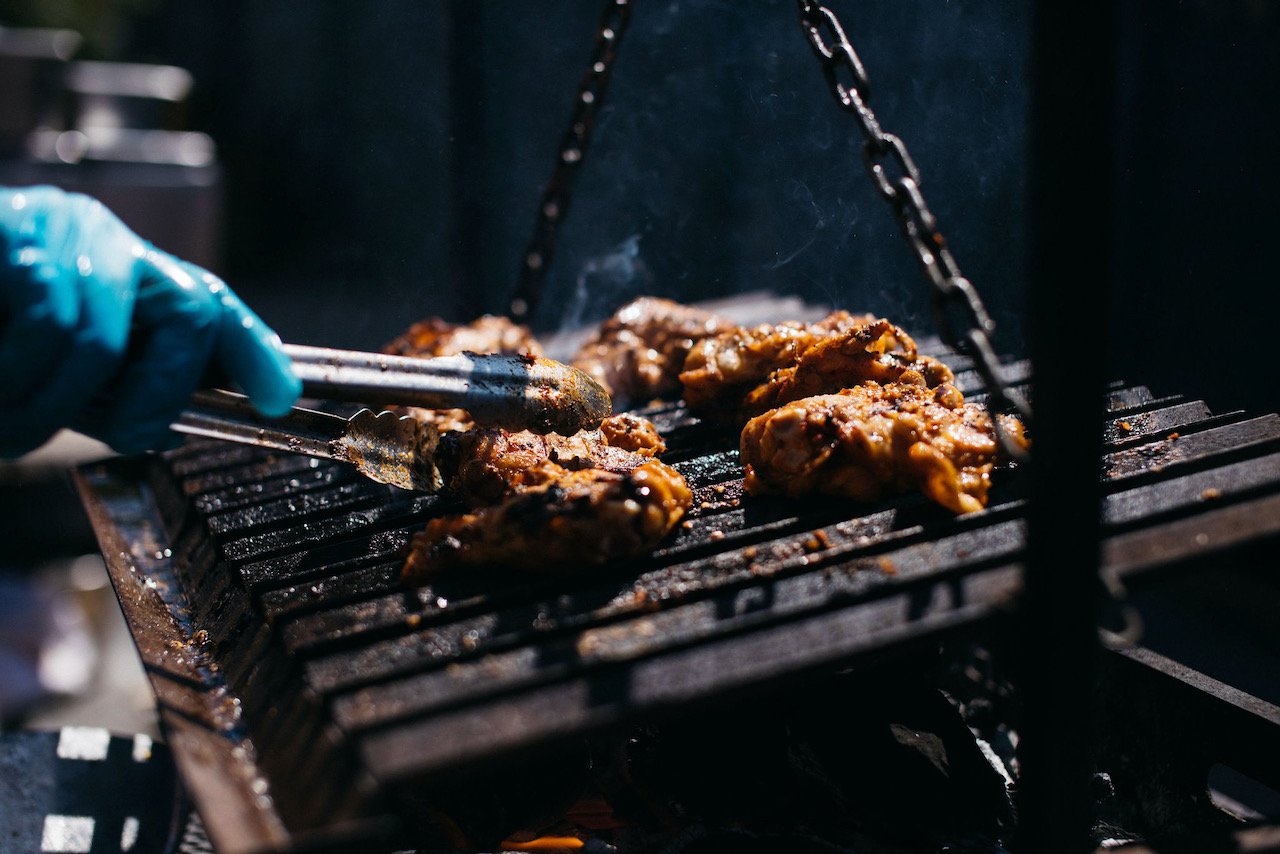 A chef cooking meat on a grill