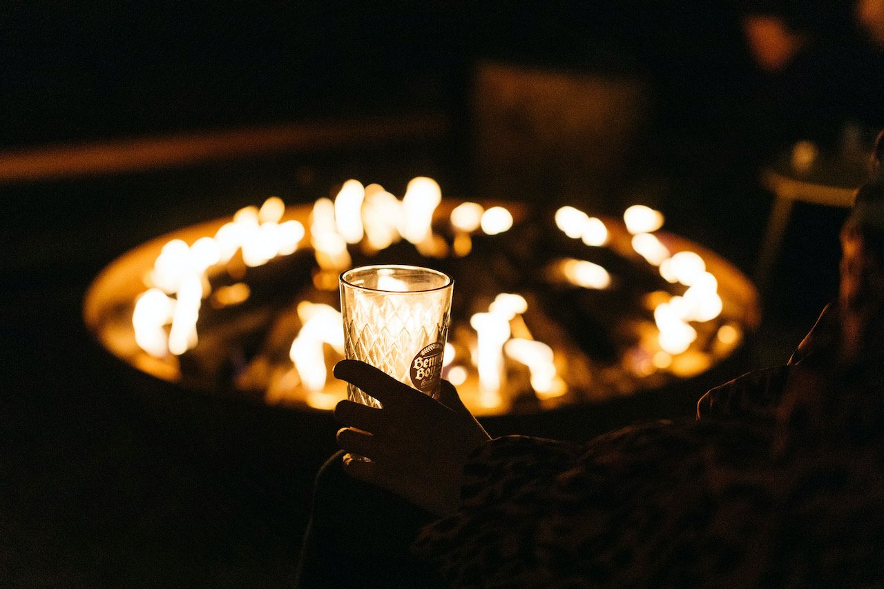 An empty cider glass in front of the fire pit