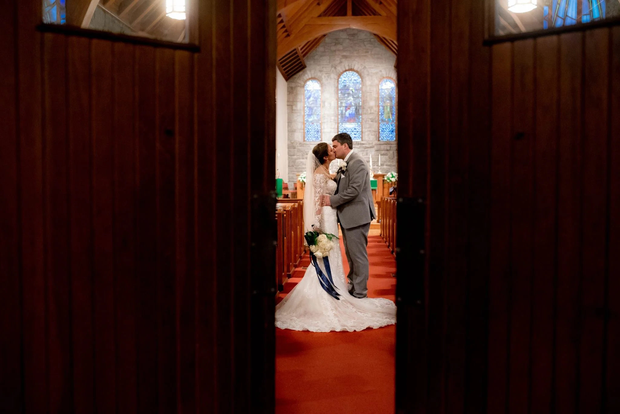 COUPLE KISSING AT St. Philip's Episcopal Church IN BREVARD, NORTH CAROLINA JUST AFTER THEIR BEAUTIFUL CEREMONY. NEXT THEY ARE OFF TO THEIR INCREDIBLE RECEPTION AT THE INN AT BREVARD.