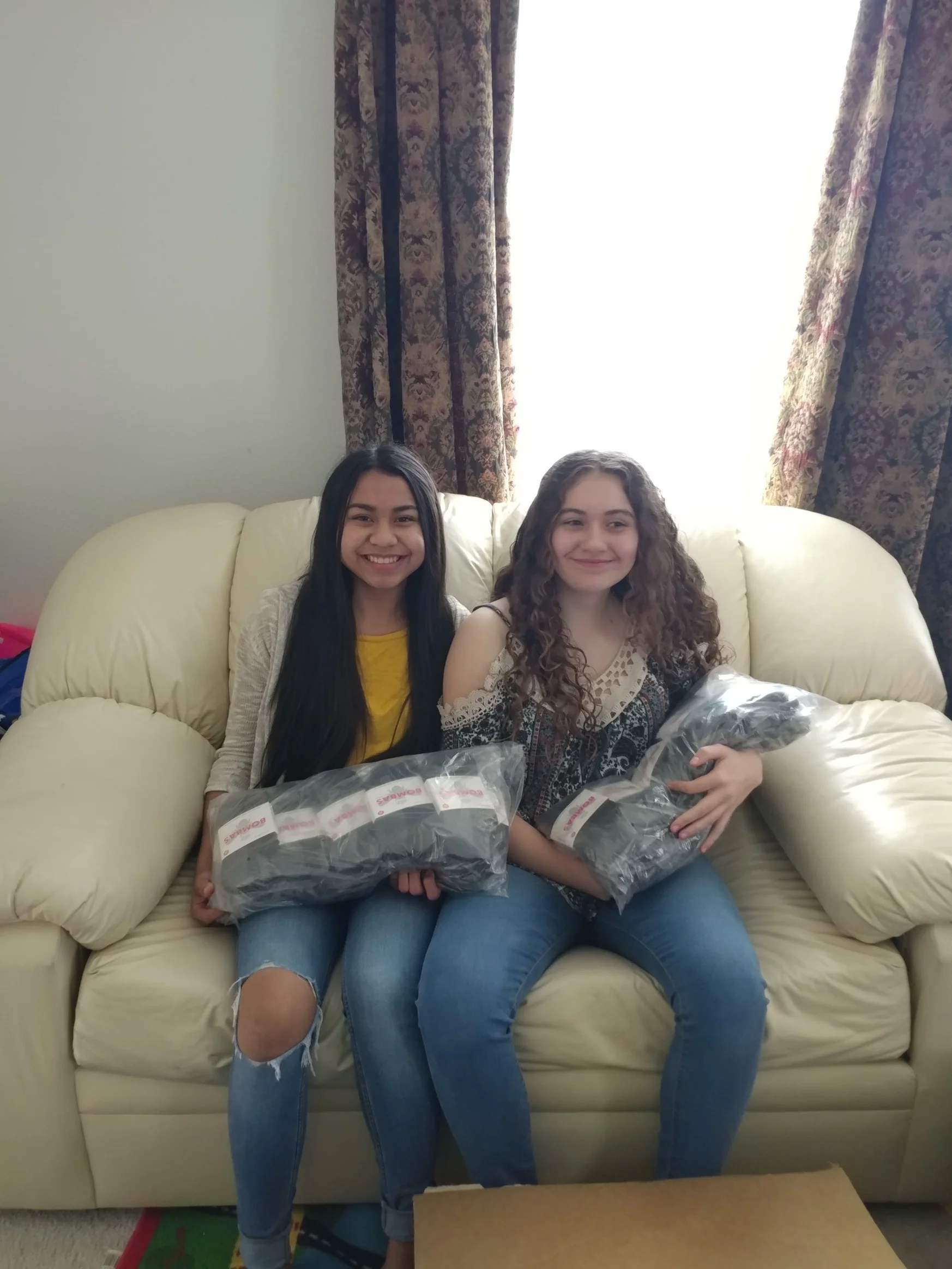 Eanna & Lily prepare to add Bombas socks to the hospitality kits they’re putting together for their community project.