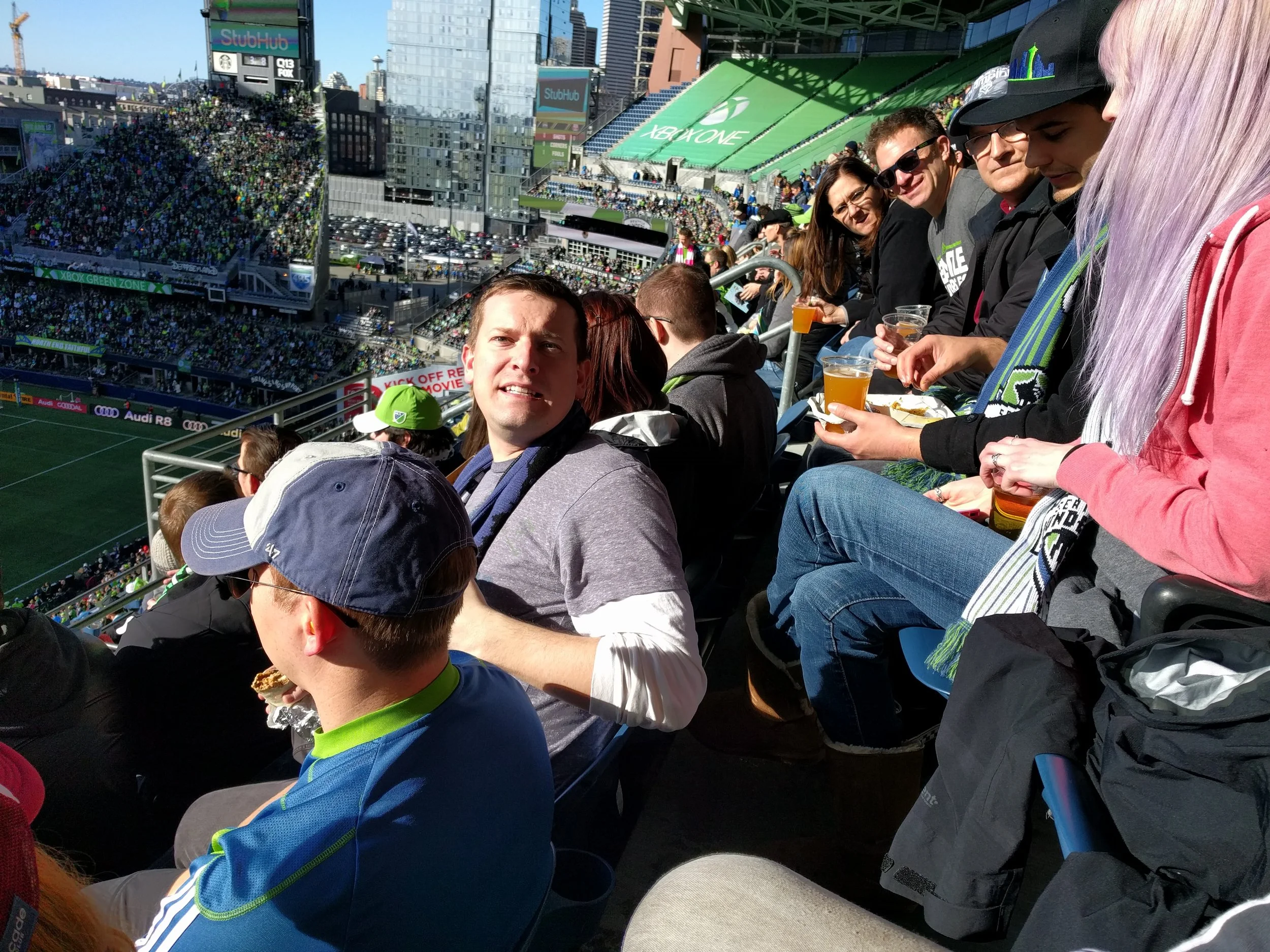 Board Member Jack Reynolds, seen here striking his “Growl-like-a-tiger” pose, surrounded by other amazing community members, donors, and volunteers cheering for the 2016 MLS Cup Champion Sounders at the 2017 Home Opener.