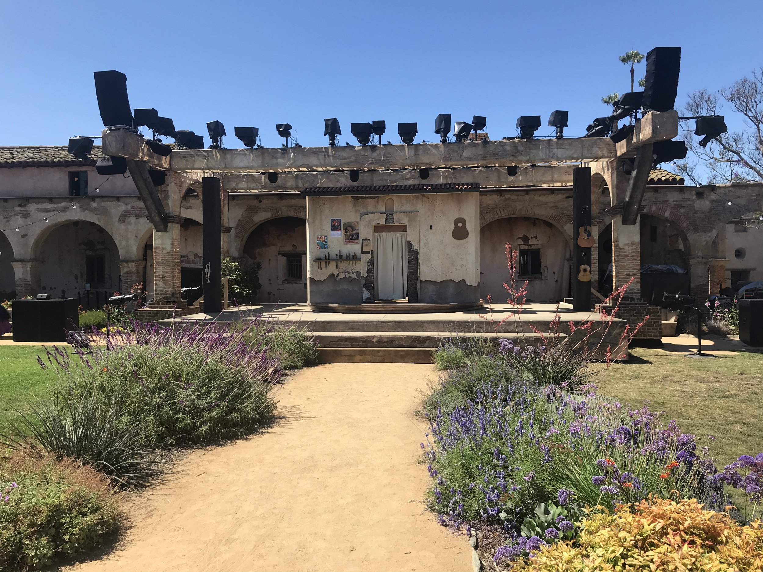  Outdoor stage at Mission San Juan Capistrano with American Mariachi set. 50-foot-long masking drop also pictured, installed behind the colonnade archways 