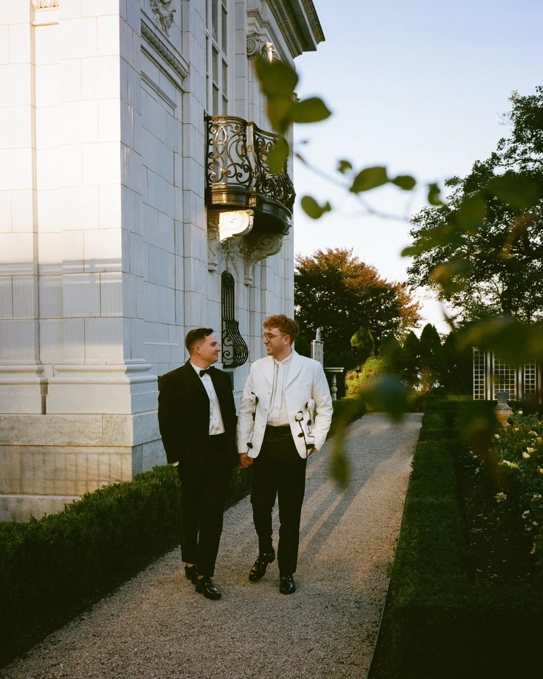 Evening scenes from Brett and Jeff&rsquo;s dreamy summer wedding: a post ceremony stroll around the Rosecliff gardens, a colorfully floral forward dinnerscape in the grand ballroom, drinks on the lawn in warm evening light, and an absolutely wild dis