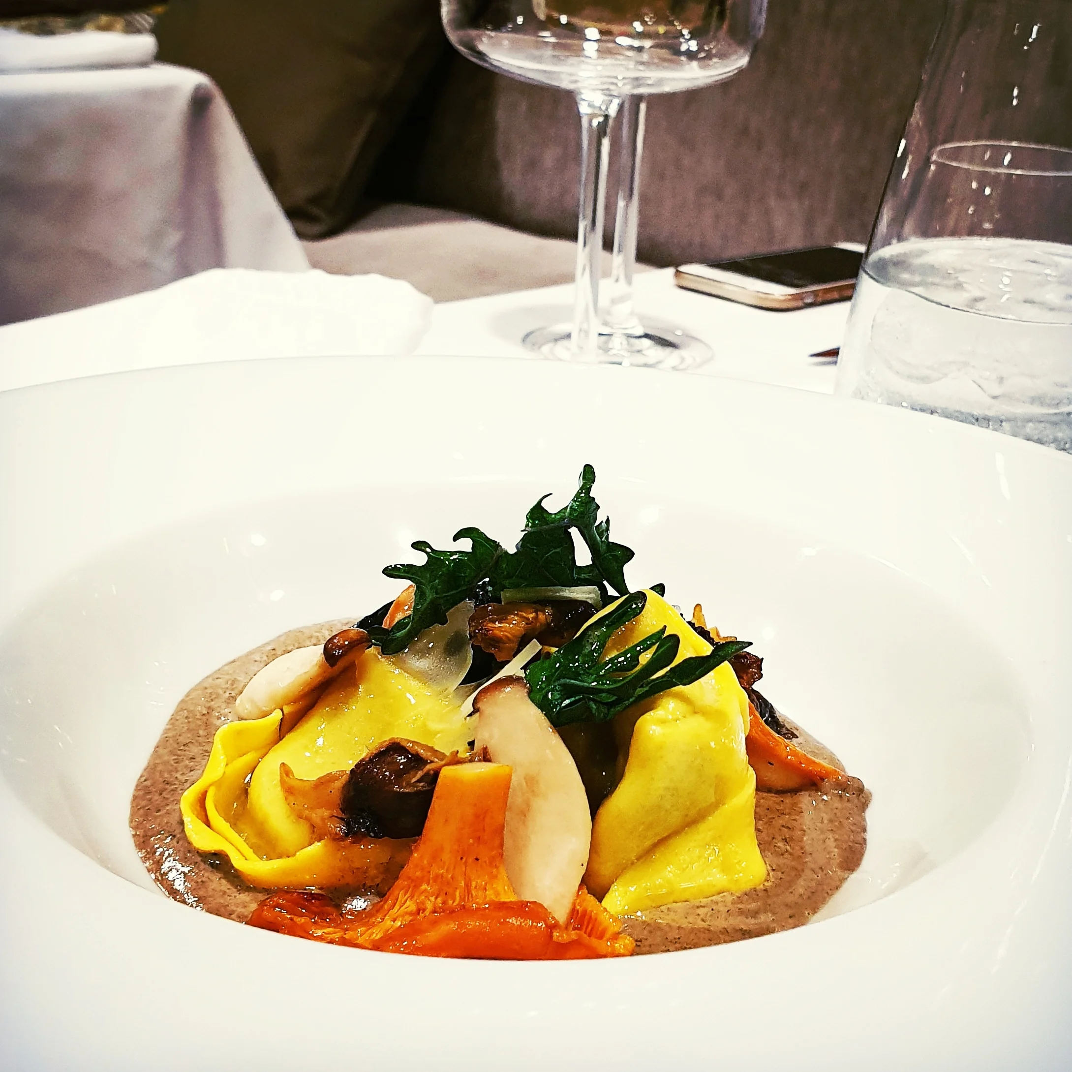 Wild Boar Tortelloni with trompette mushroom sauce, garnished with wild mushrooms and rainbow kale