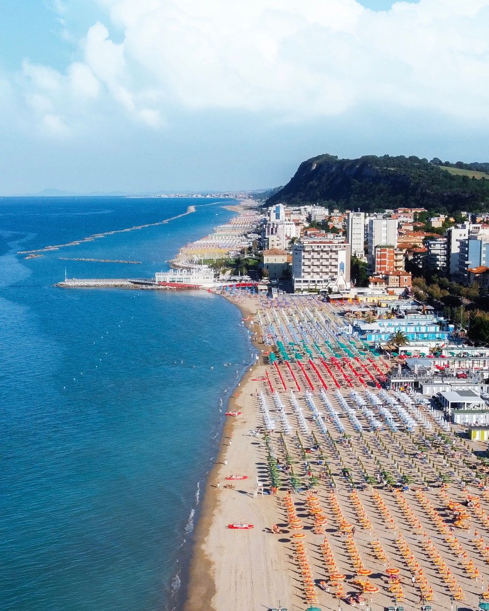  Pesaro’s long beach of fine white sand is dotted with sun beds &amp; parasols in neat rows right up to the shoreline 