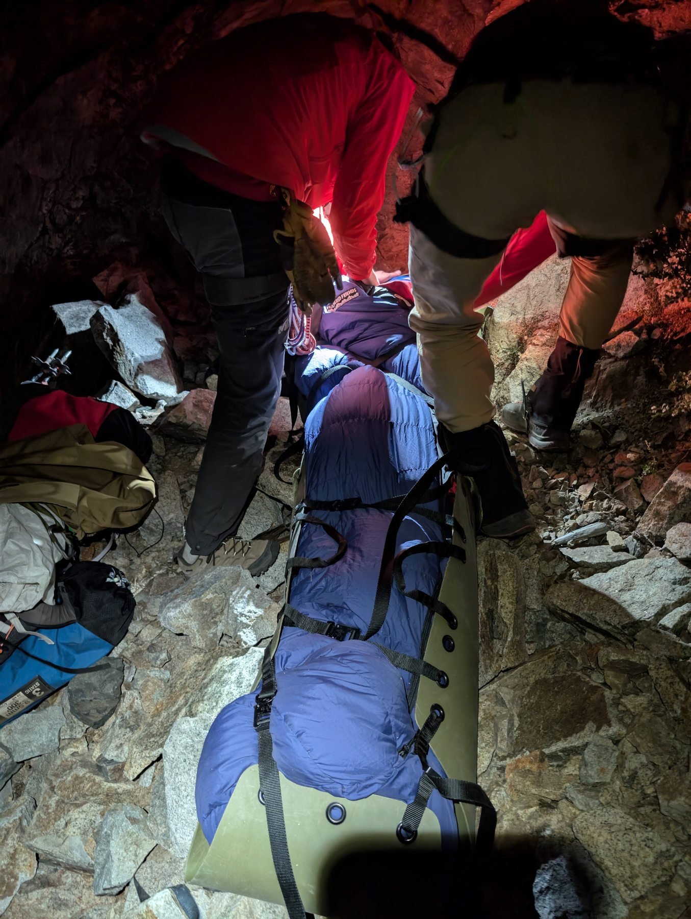 Rescuers package Scott in a Sked at night with his face out of view