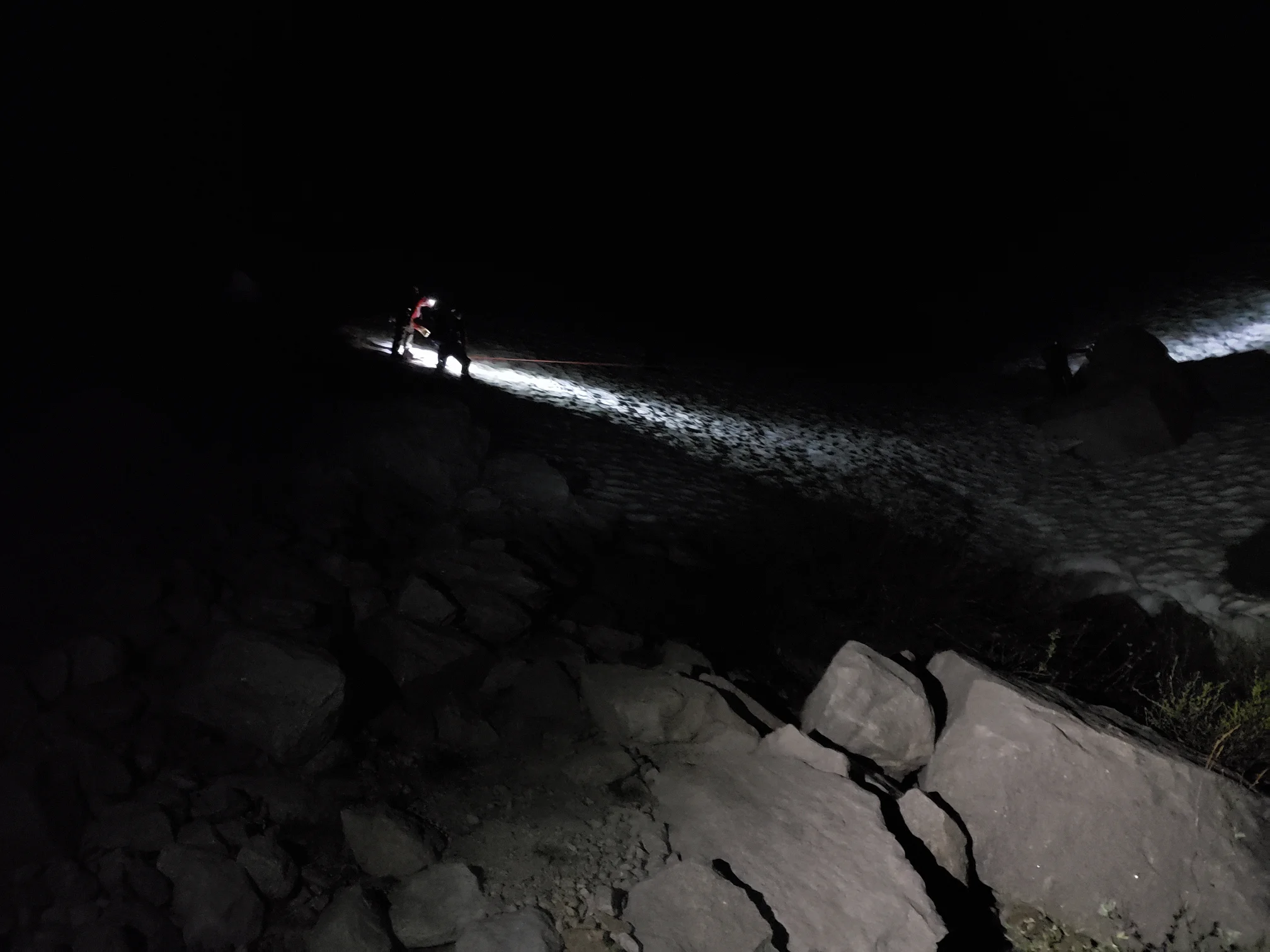 Searching for the subject on the steep snowfields via roped belay. Image by B. Beck