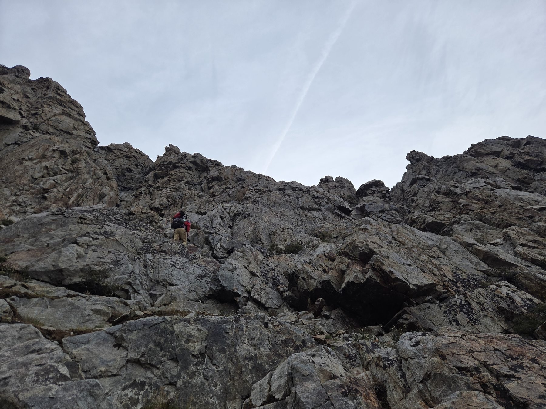 A rescuer appears small among the steep rocks on Carson Peak