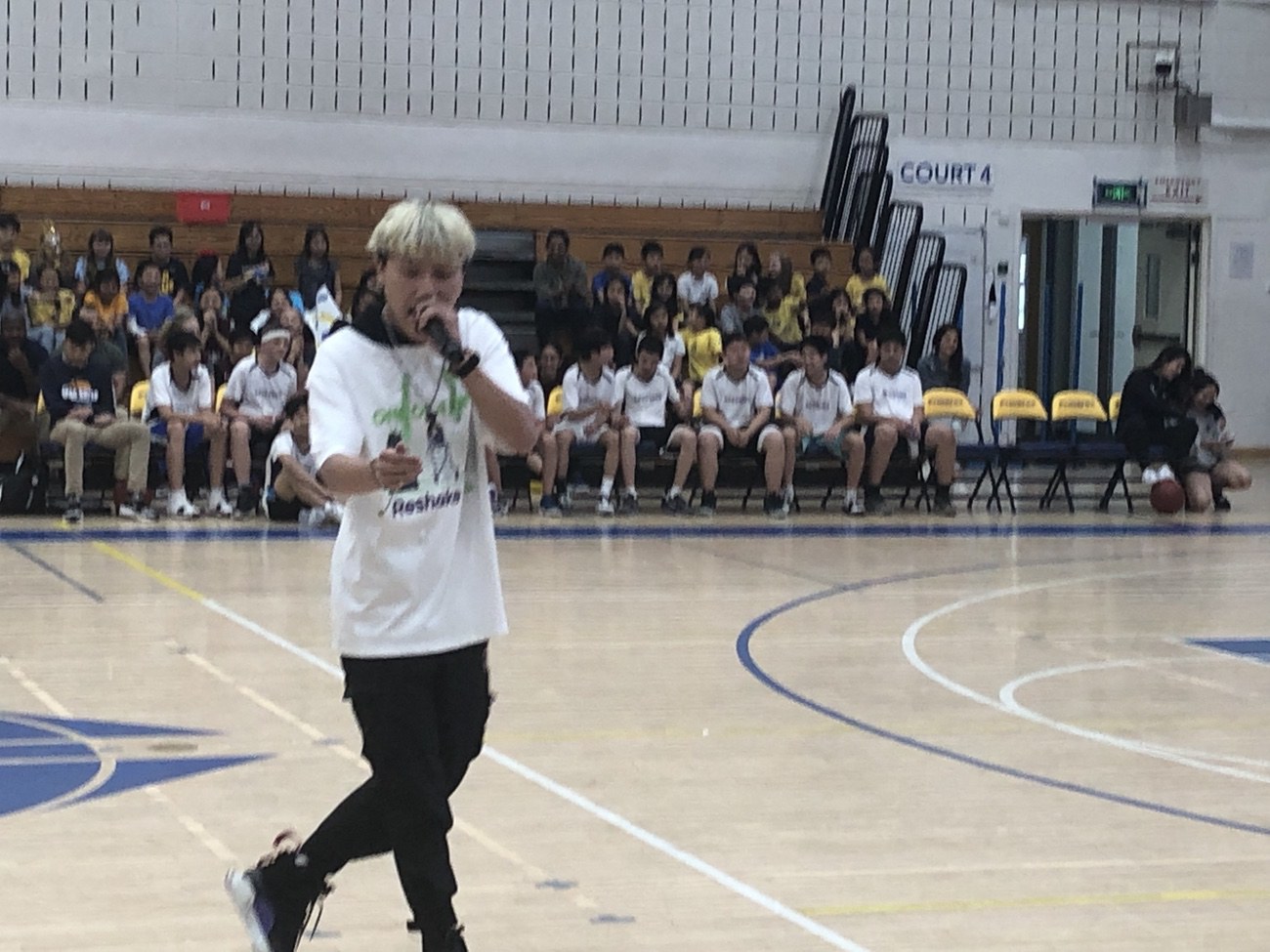 Mr. Famous sings his rap as students cheer and stomp (image supplied)