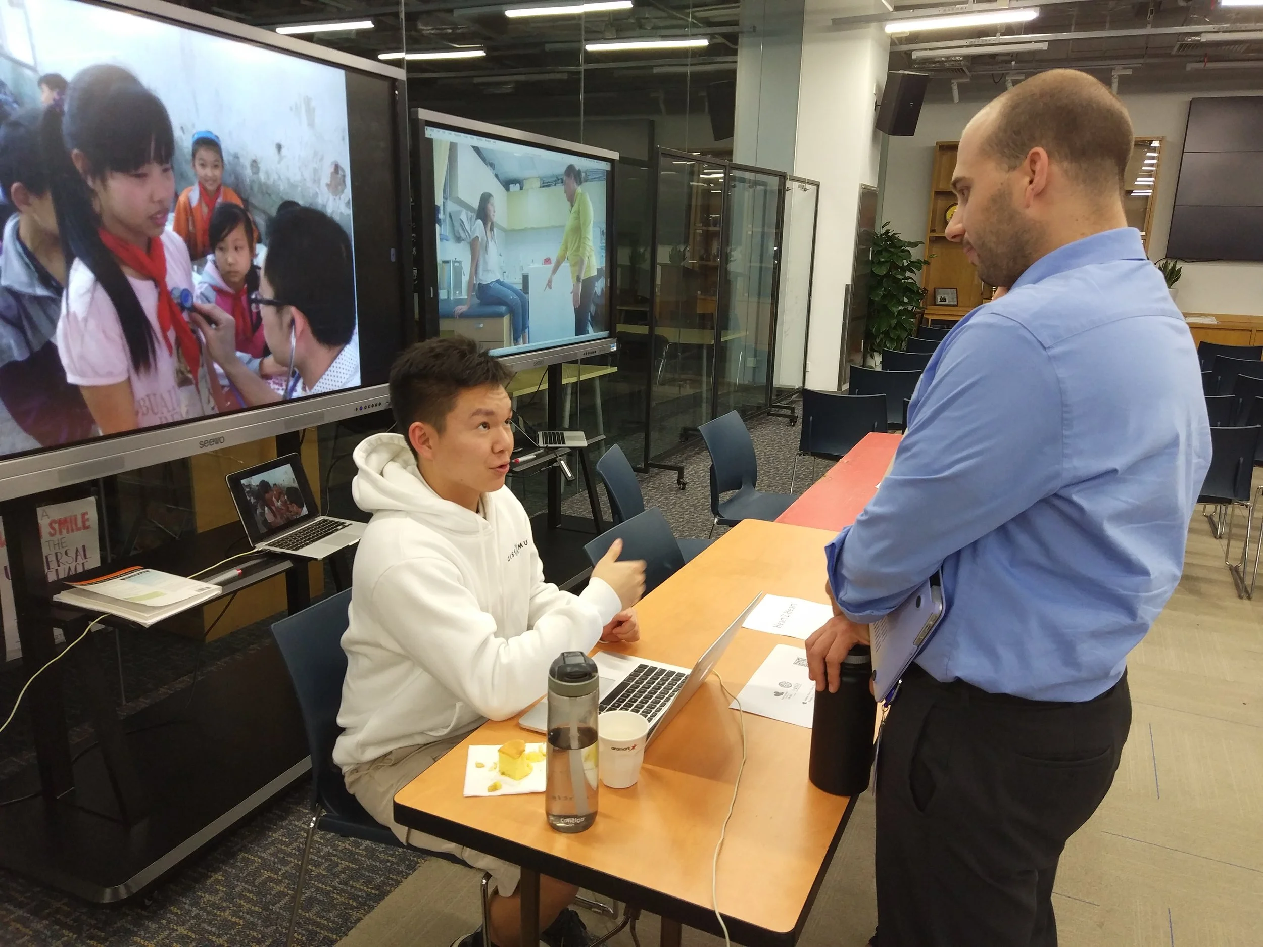 Grade 11 student Corey Z sharing information about the Heart to Heart club with Concordia Marketing Director Bo Hardegree at the May Service Celebration.