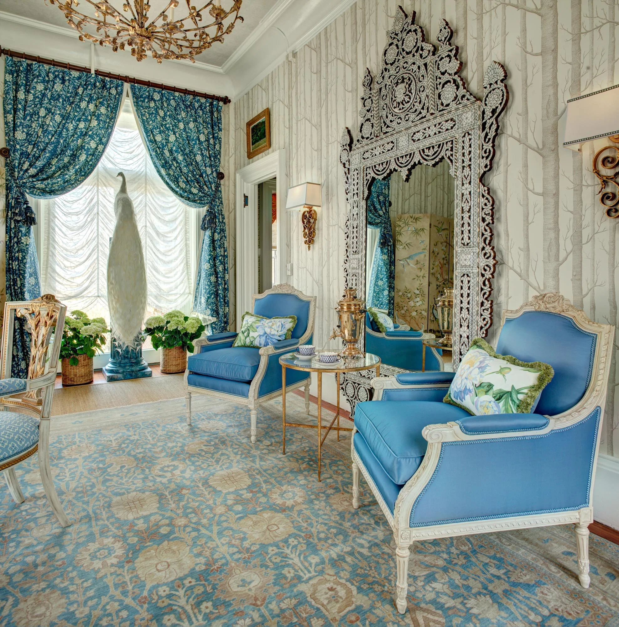 Living room with blue chairs and mirror in the wall