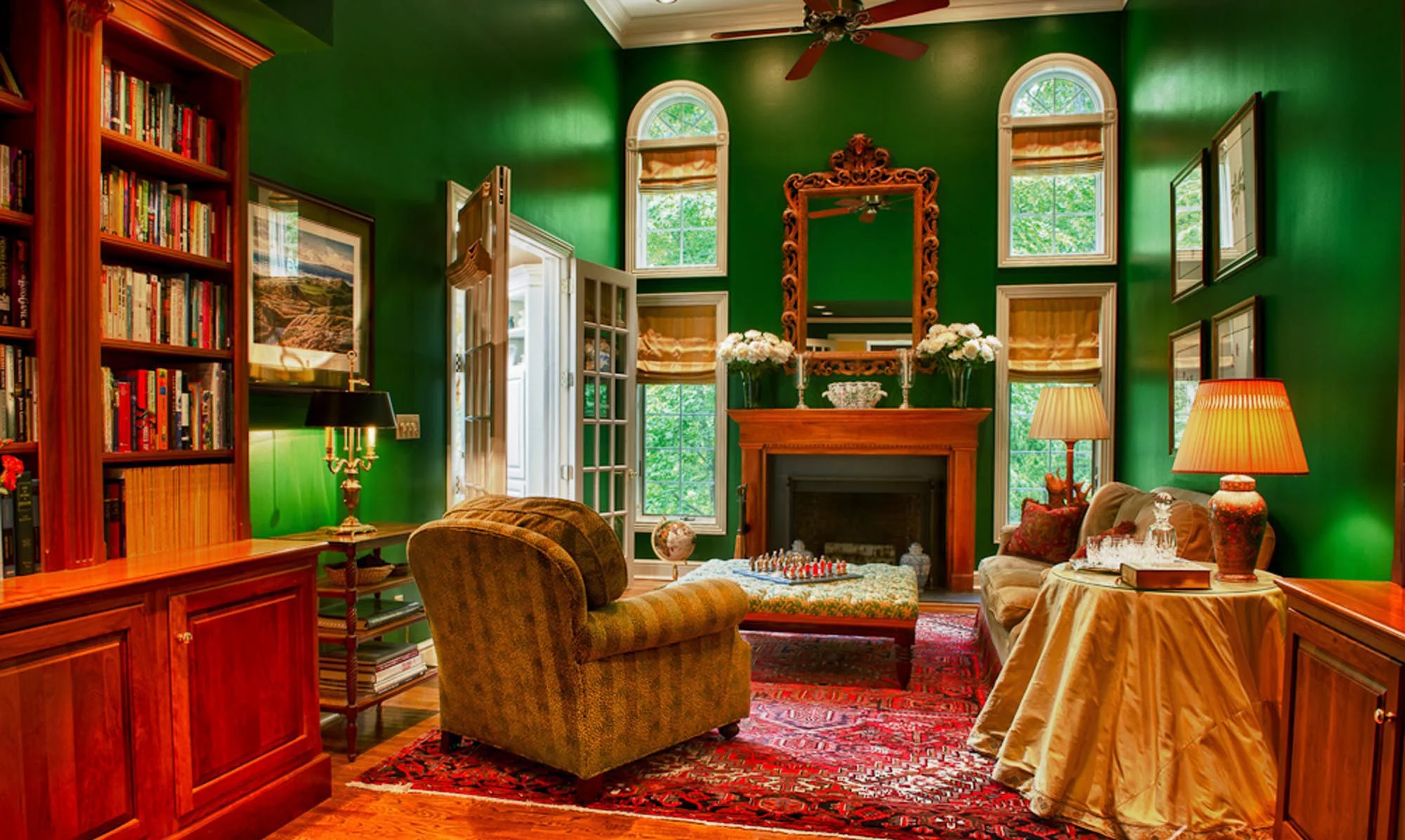 Warm living room in green paint with printed carpet and fireplace