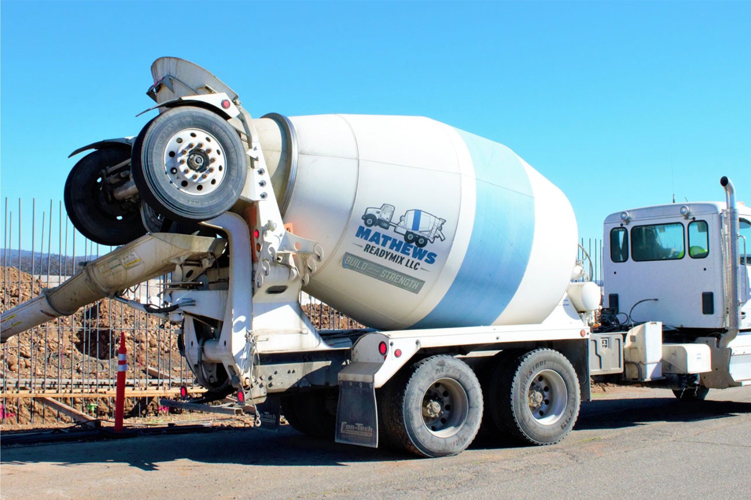 a white cement truck with an encircling blue line that reads Mathews Readymix LLC.v2.jpg