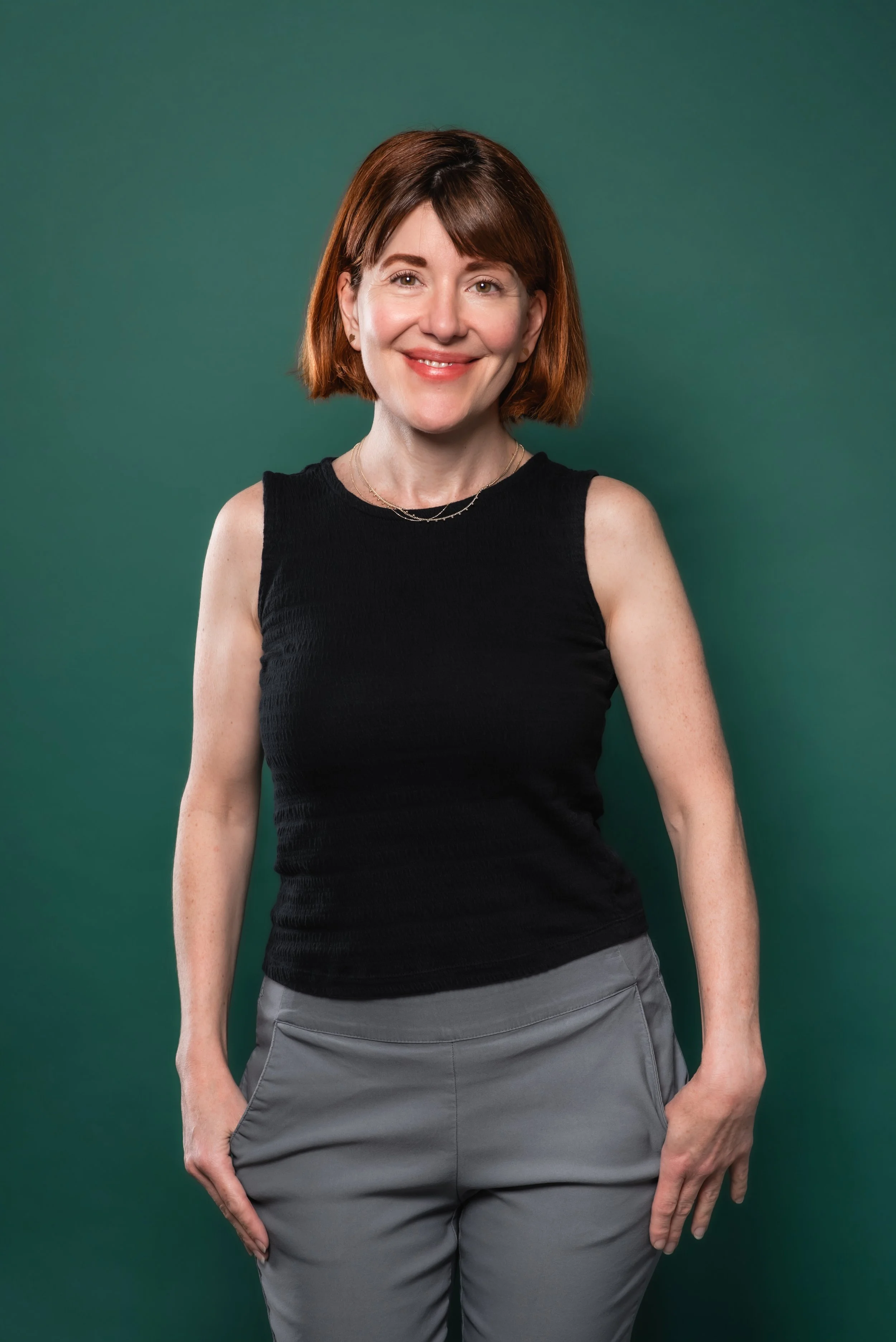  In studio headshot of a mental health professional in Vancouver, Washington with a forest green backdrop to match website branding colors. 