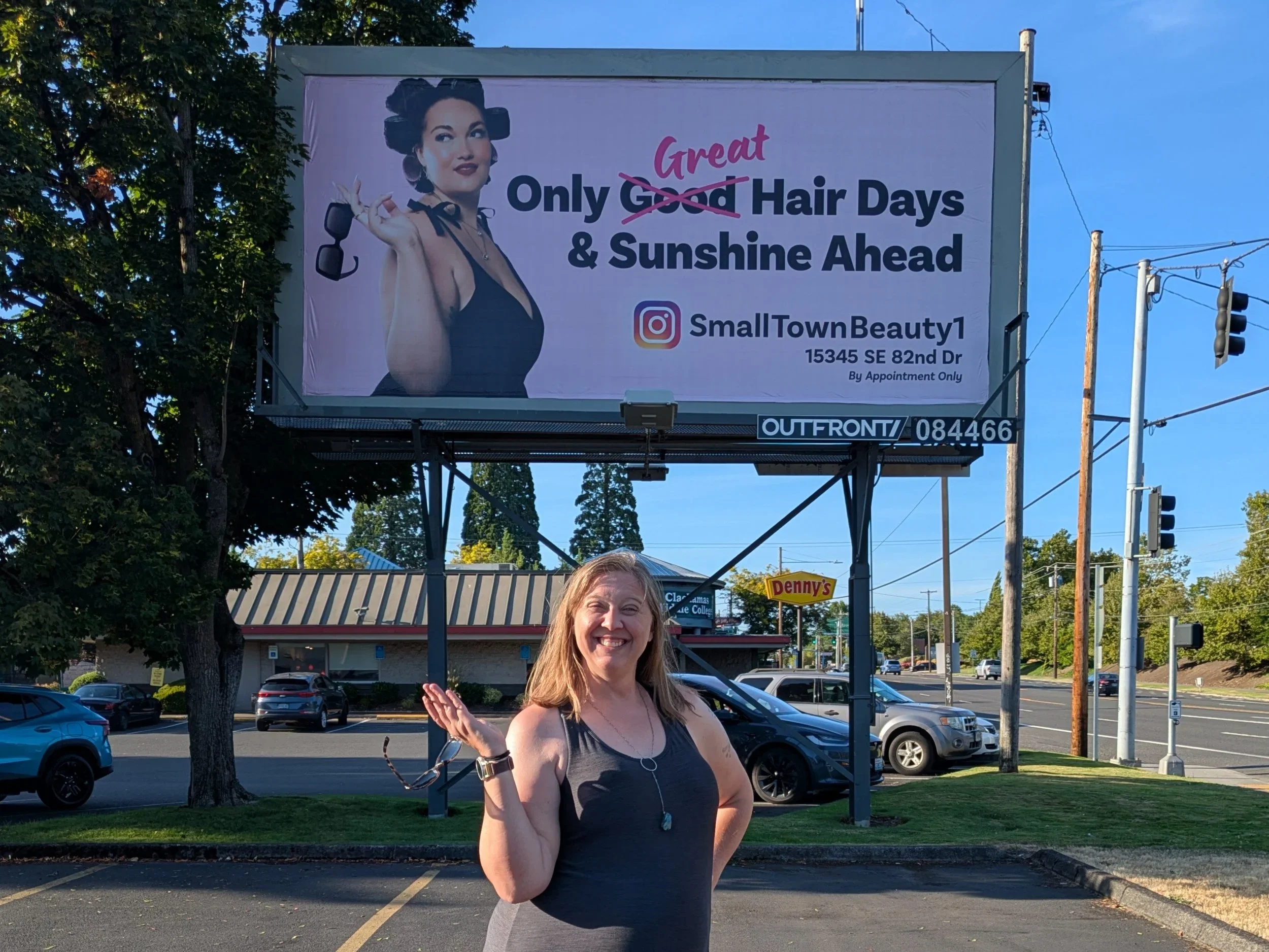 Woman stands in front of a promotional beauty billboard in Vancouver, Washington.
