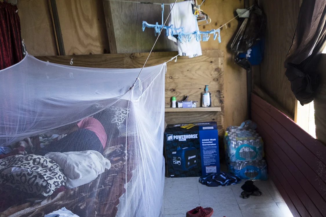 A young girl sleeping in her new bed after the roof of her home was carried away by Maria. This structure also needed a lot of repair.