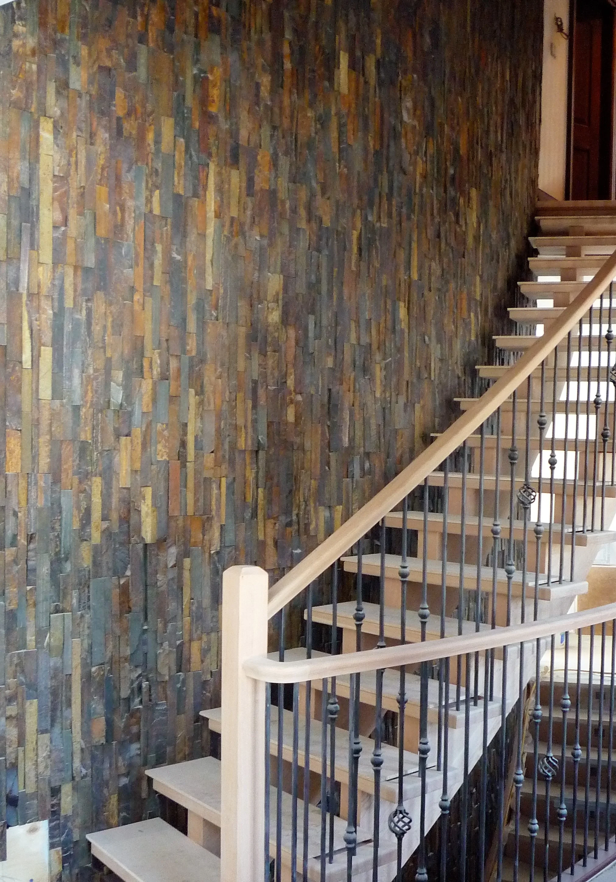Living area hardwood staircase stone wall.jpg