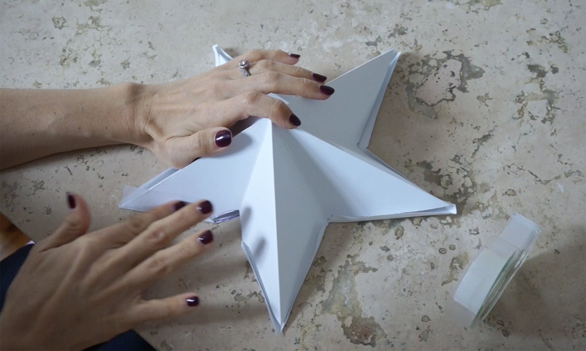 fold the edges over and tape the two pieces together / pega las hojas de cartulina con cinta