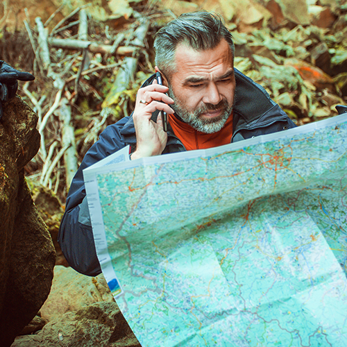 Adventurer squinting at a map and having a phone call
