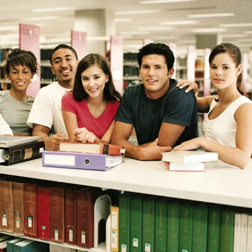 Five People leaning on a counter in a library