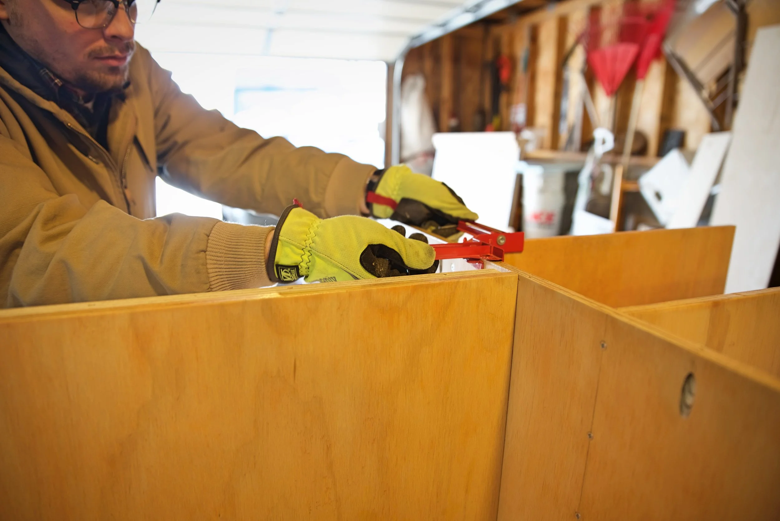 Ian removes a corner clamp after joining the chuck box shelf to the cabinet case.