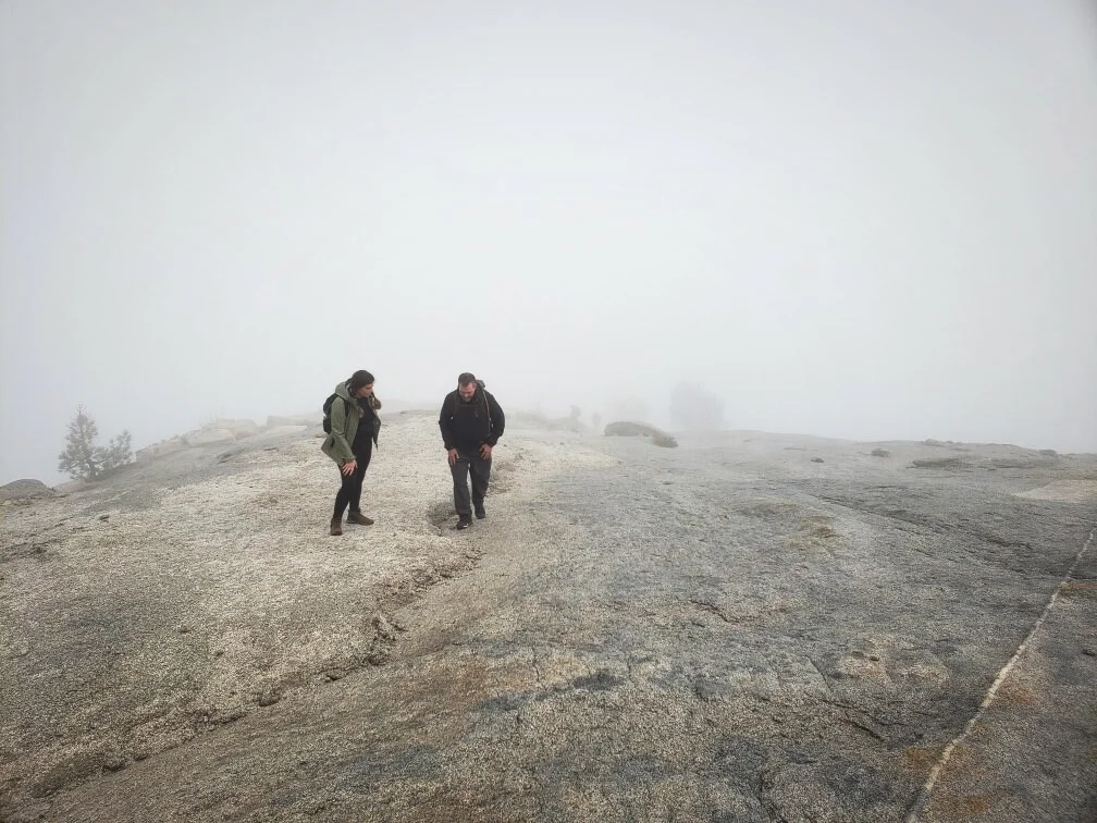 Ian’s dad and sister climbing up Sub Dome surrounded by the completely white void of the clouds.