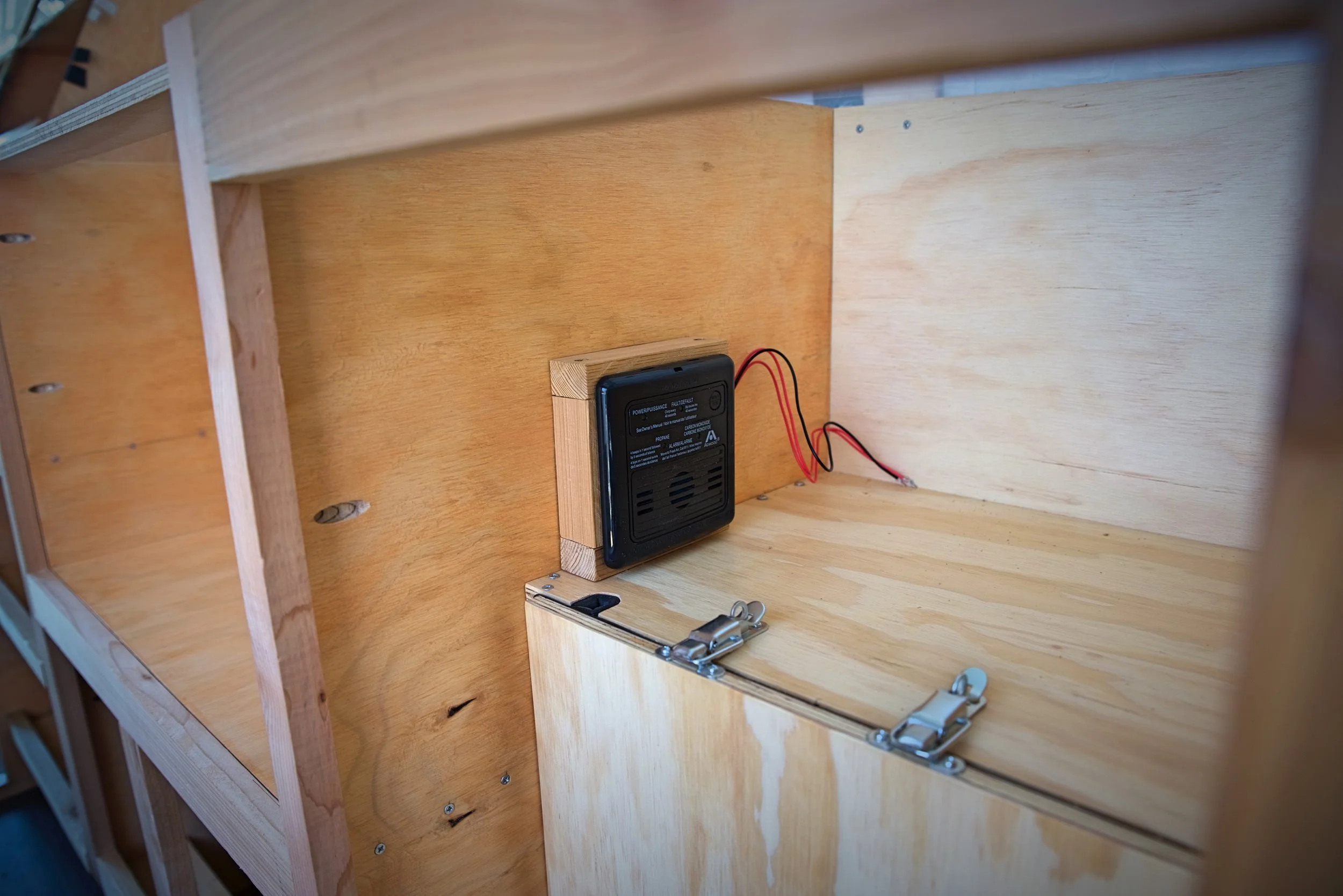 The propane and CO detector mounted above our propane locker before we finished the cabinets.