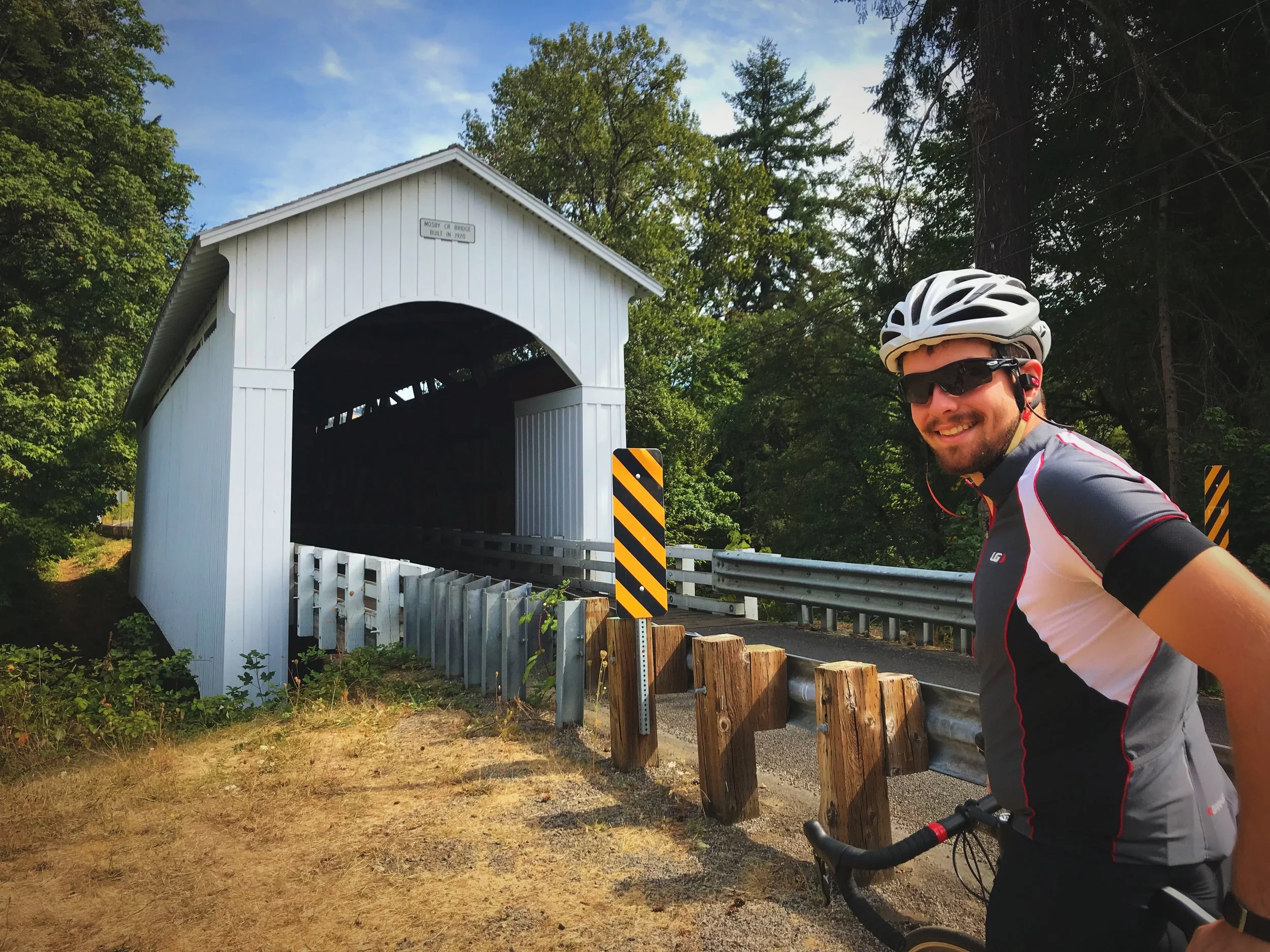 Ian posing by the picturesque Mosby Creek Covered Bridge along the Covered Bridges Scenic Bikeway near Cottage Grove, Oregon.