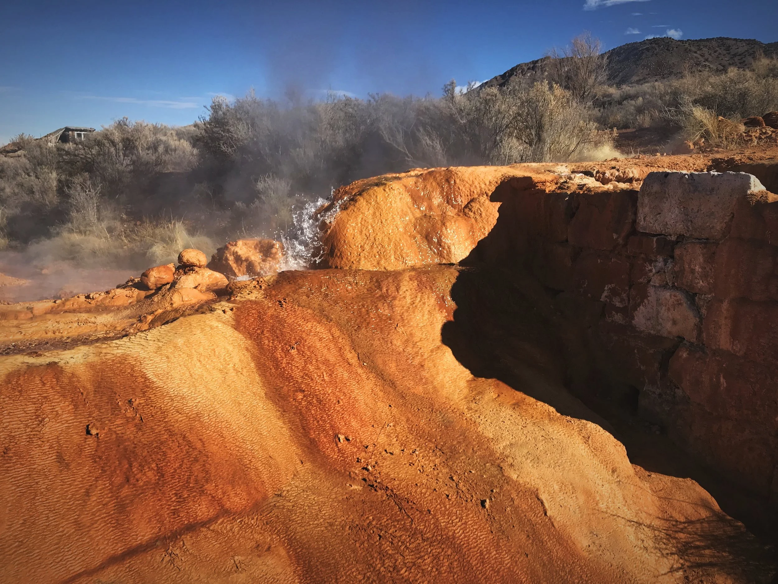 Water trickles through a travertine channel to cool down before the soaking pools.