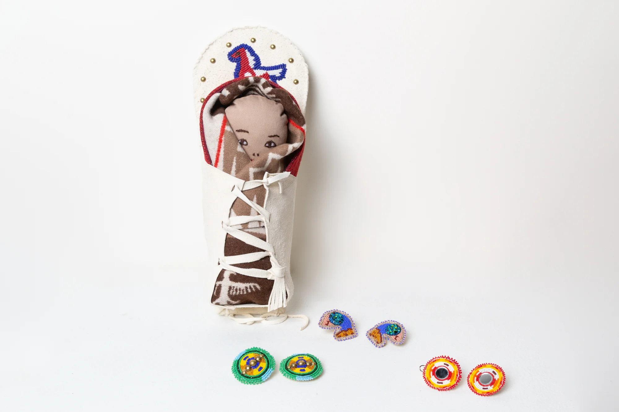 Baby Cradle Board leather, glass beads, textiles, 2010 photo by Mel Carter Beaded Earrings glass beads and other materials, 2019 photo by Mel Carter