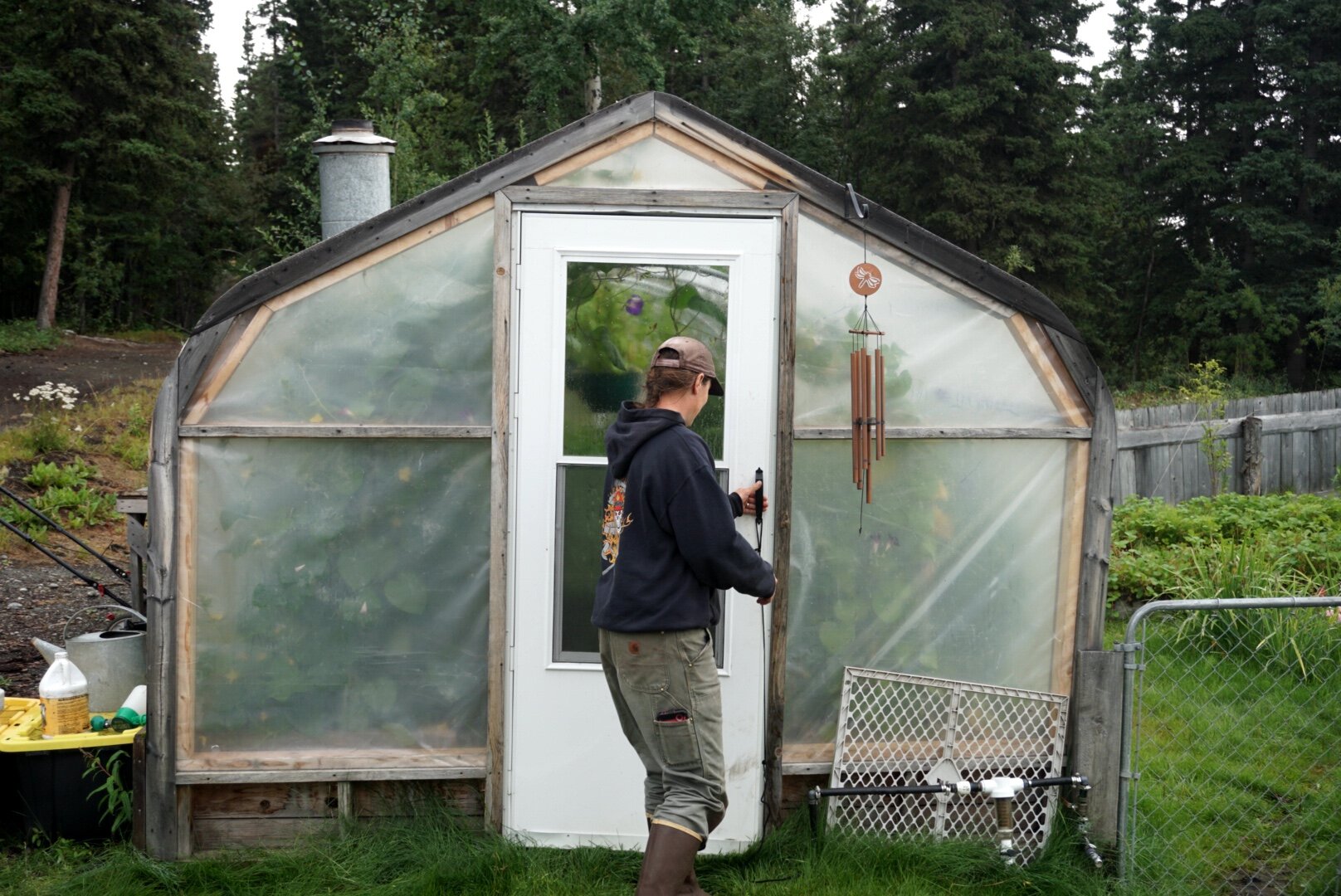  Tenley Nelson opens the door to her greenhouse in August 2019. 