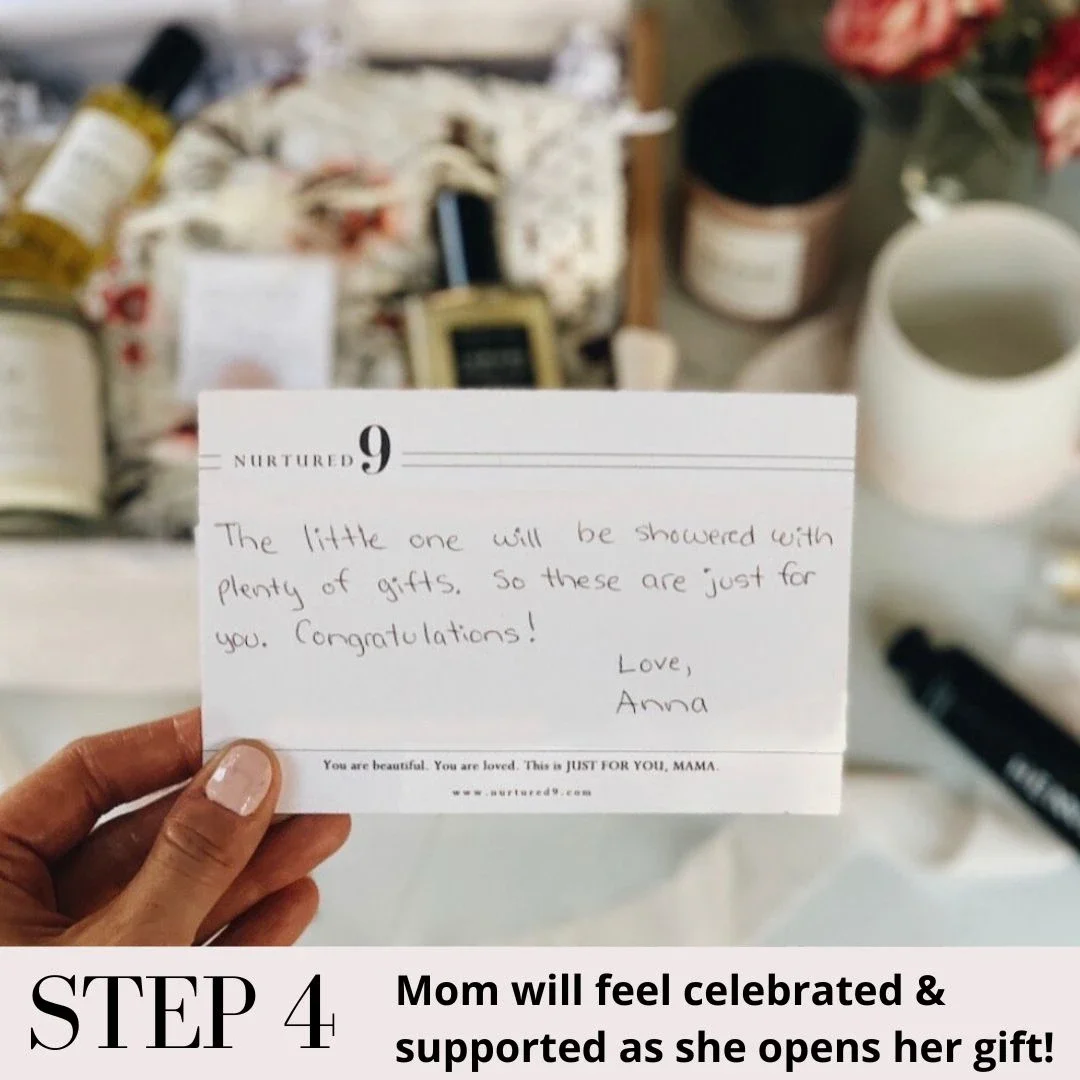a mom's hand holding a handwritten notecard in front of a gift box