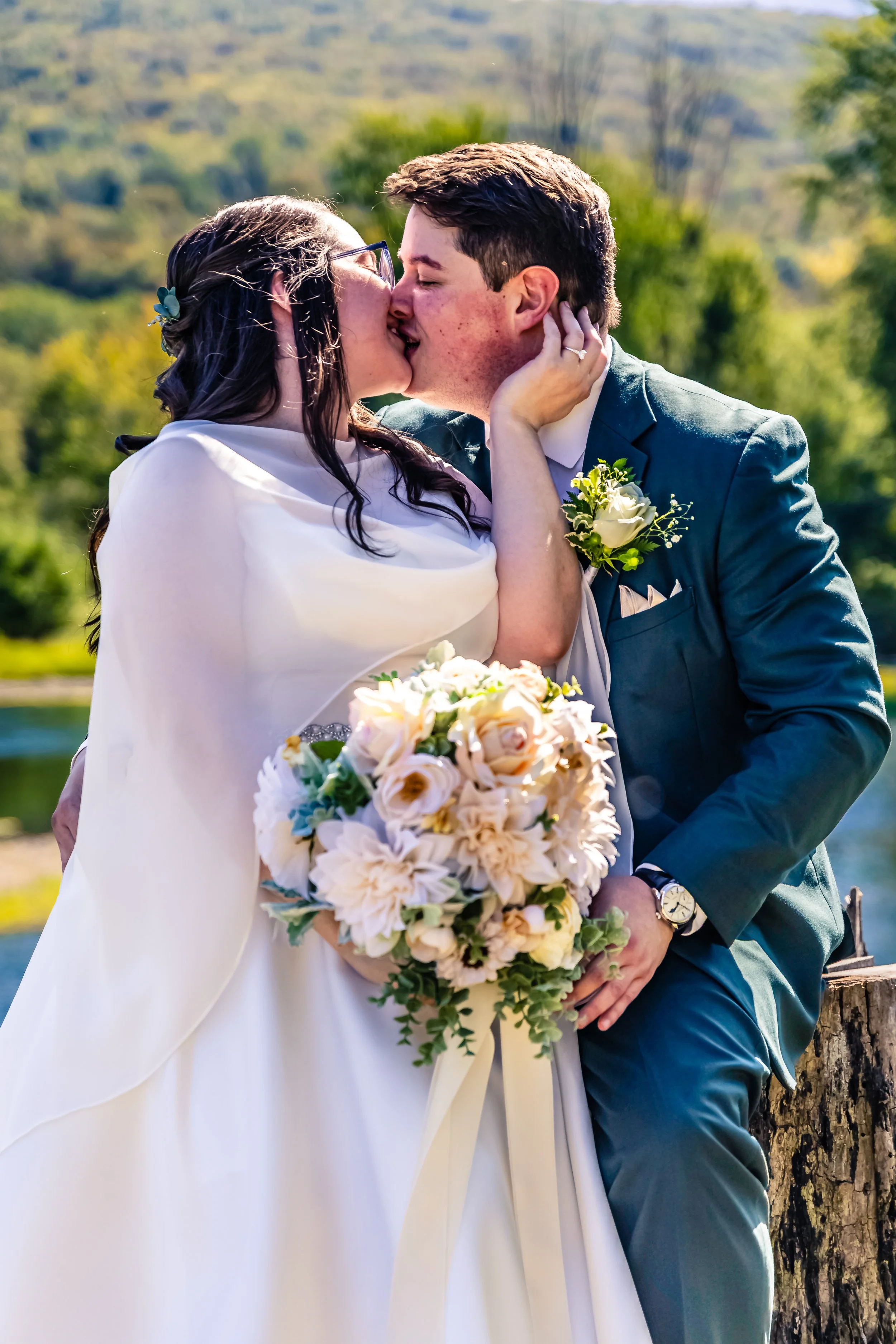 bride sitting on her grooms lap, kissing