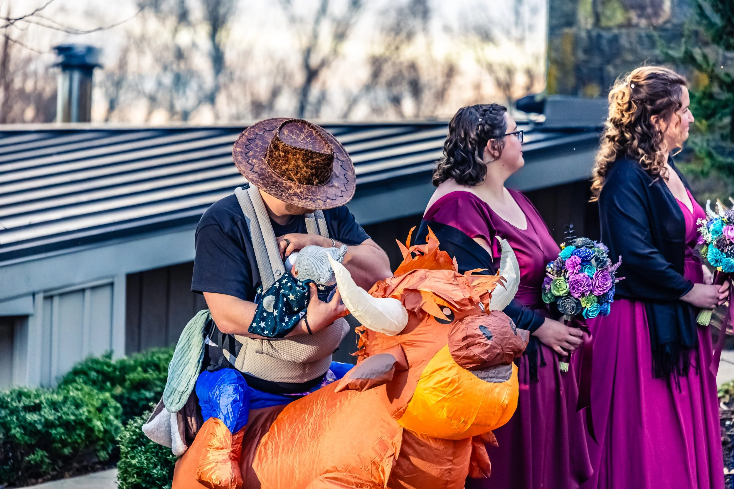 People dressed in costumes, including a person in a dragon costume, participating in a celebration or event outdoors.