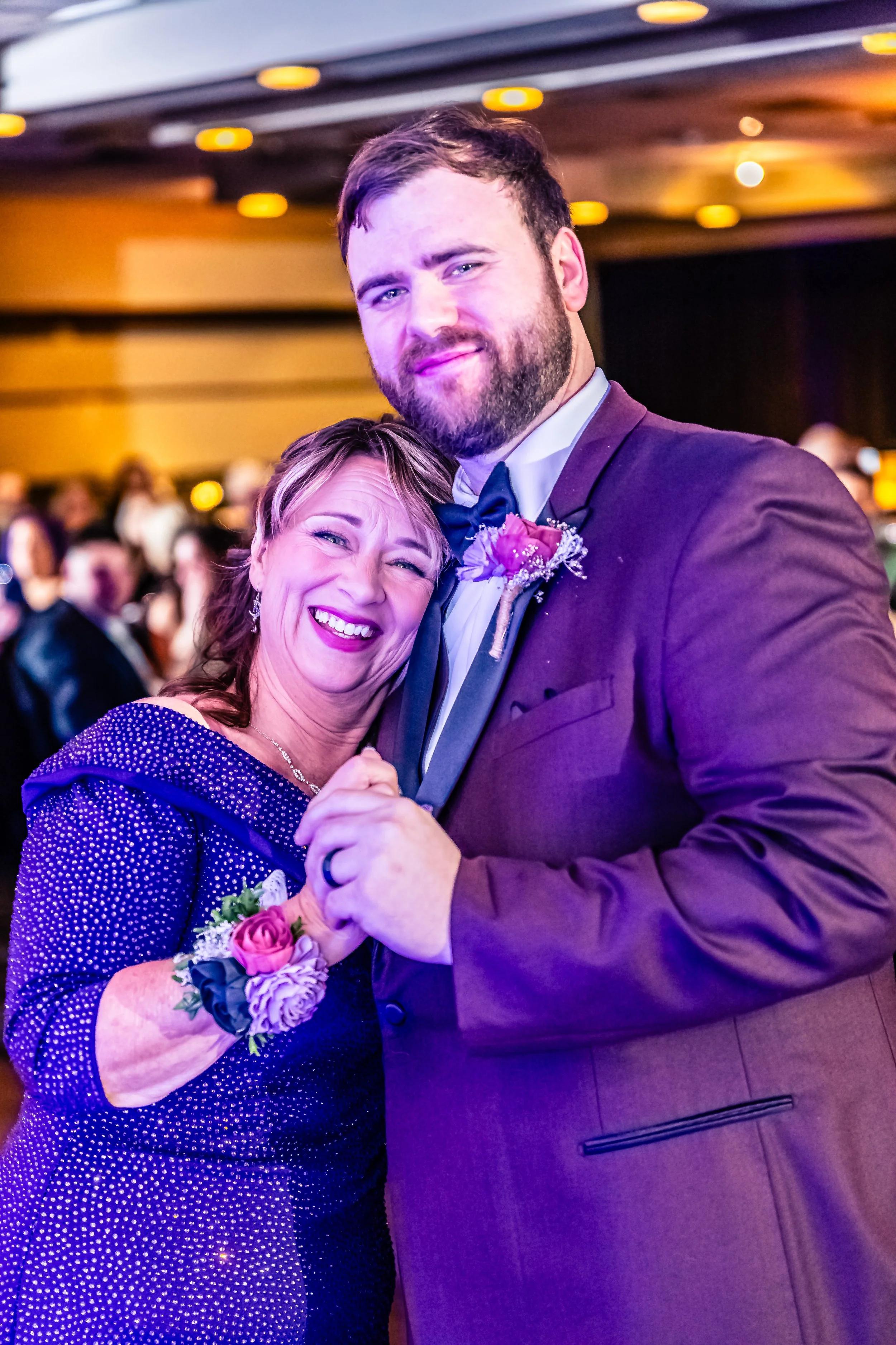 A woman and a man dressed in formal attire dancing at a wedding reception.